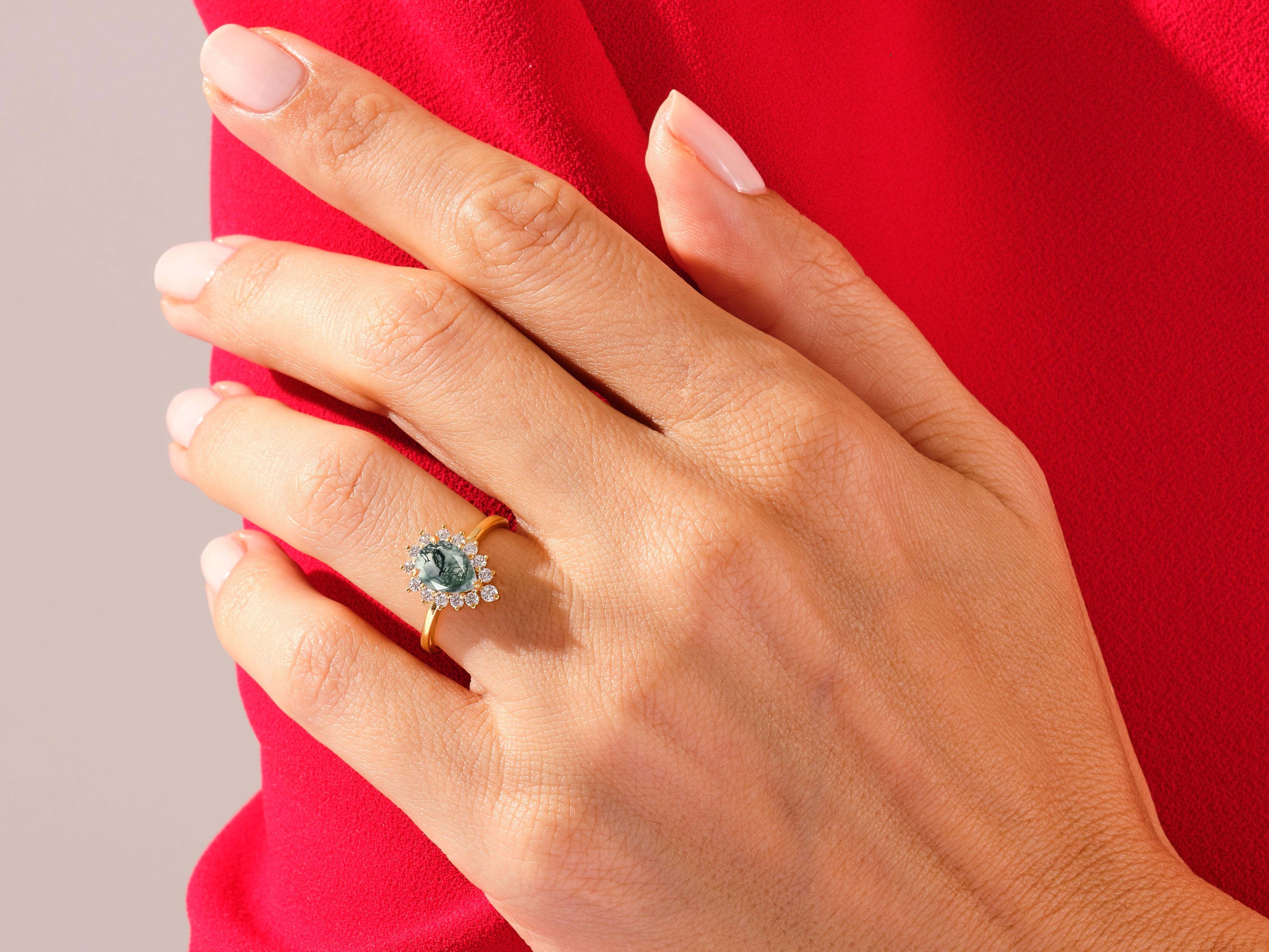 Gold ring with green gemstone and diamonds on a hand