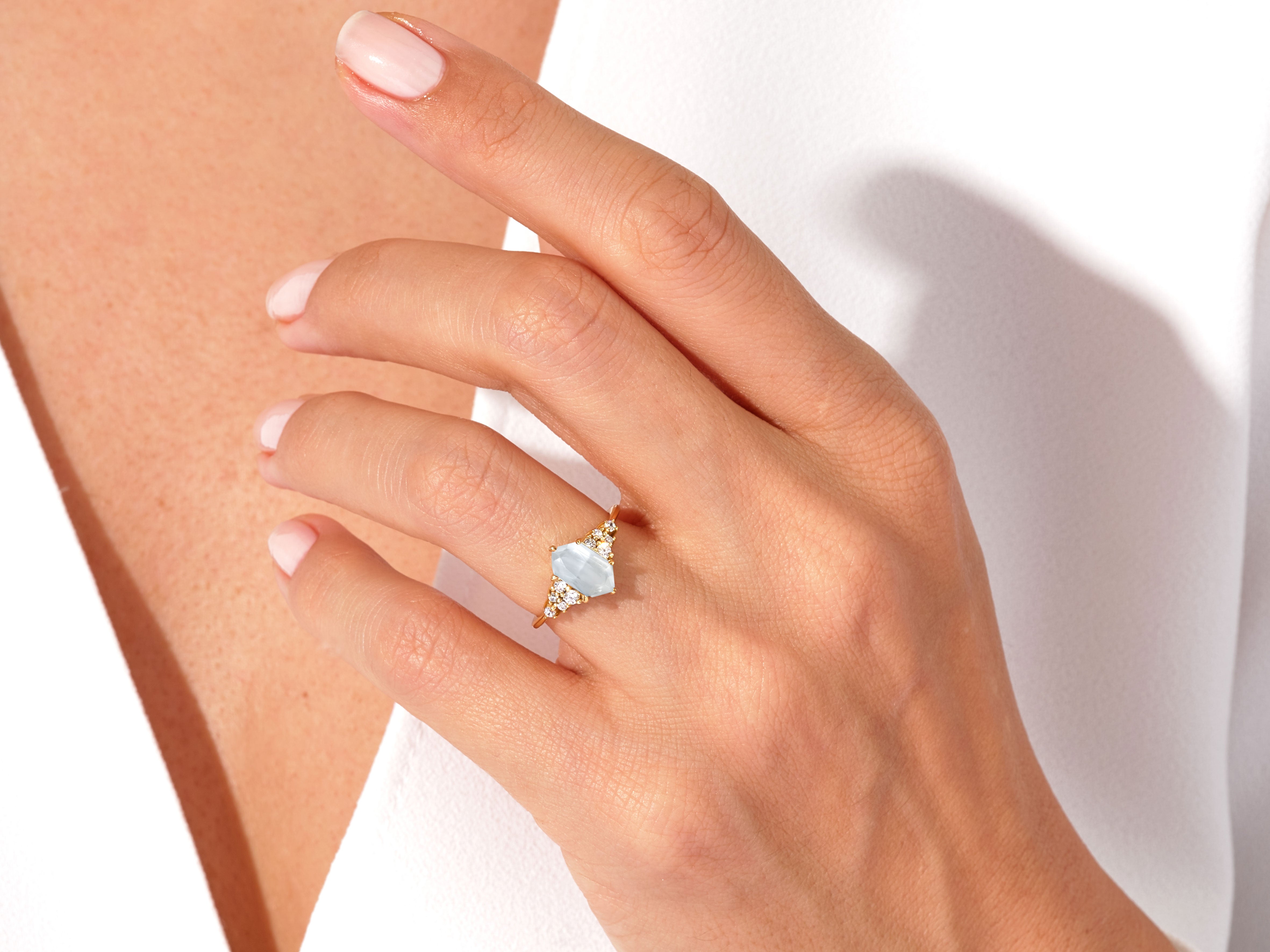 Gold ring with aquamarine and diamonds on a woman's hand