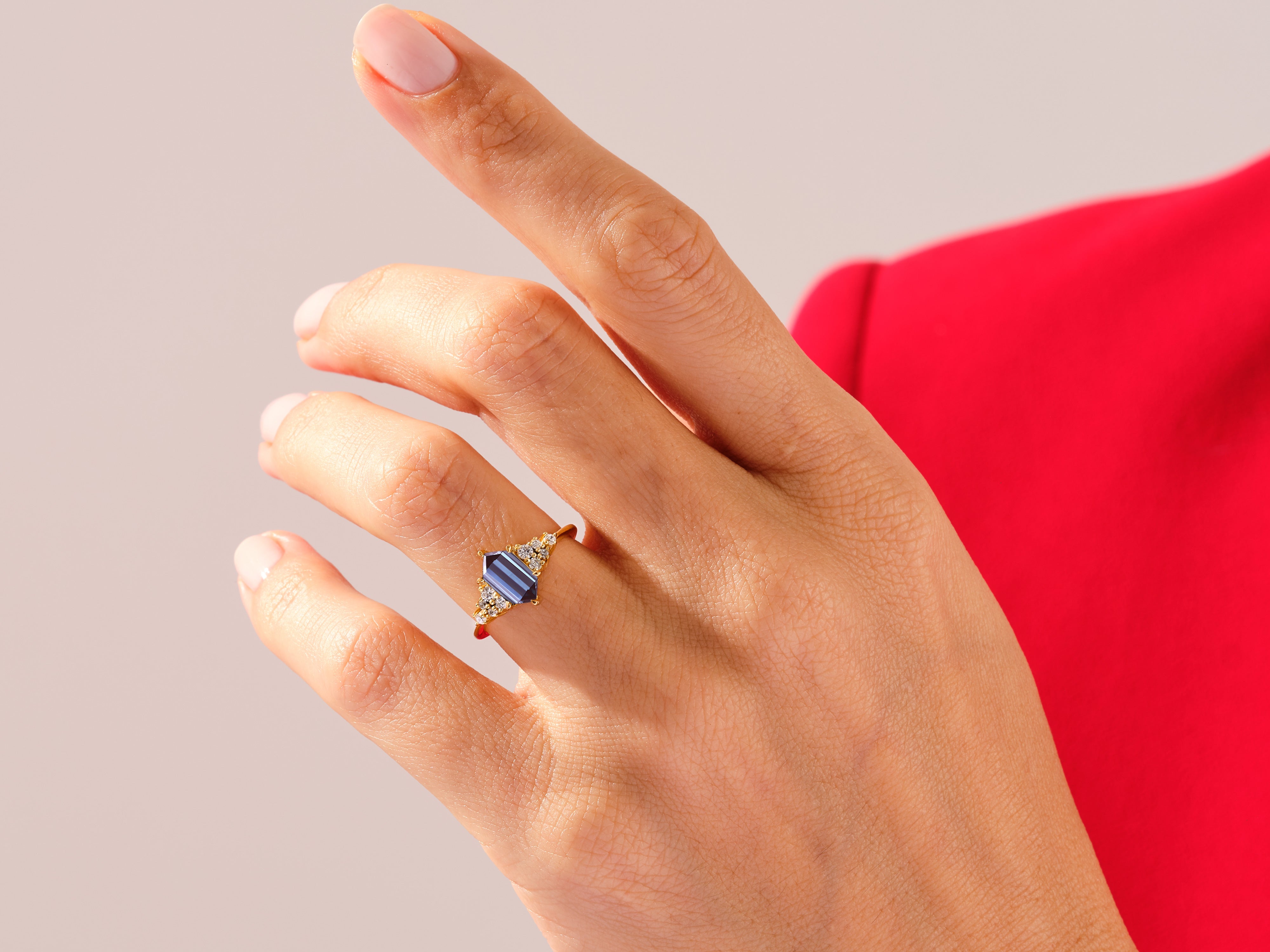 Gold ring with blue gemstone and diamonds on a hand