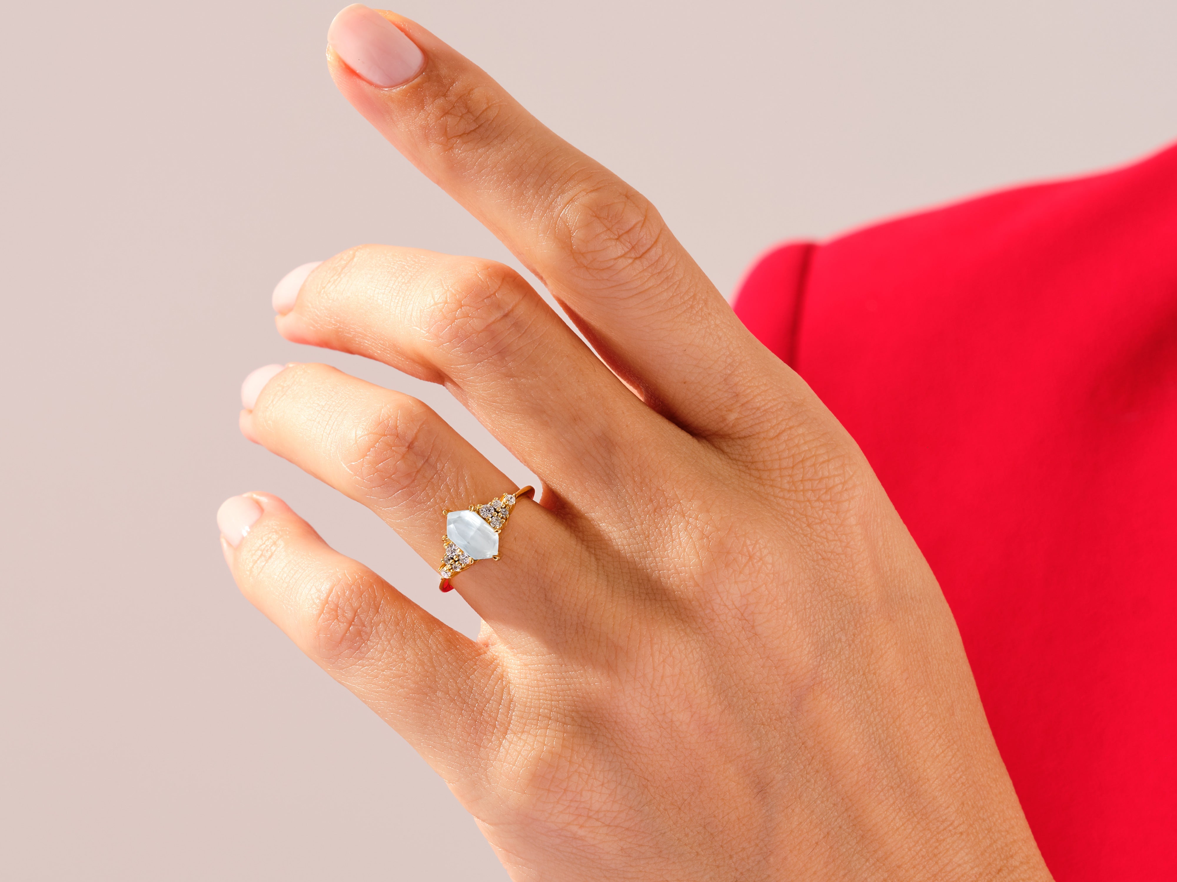 Gold ring with marquise aquamarine and diamond accents on hand