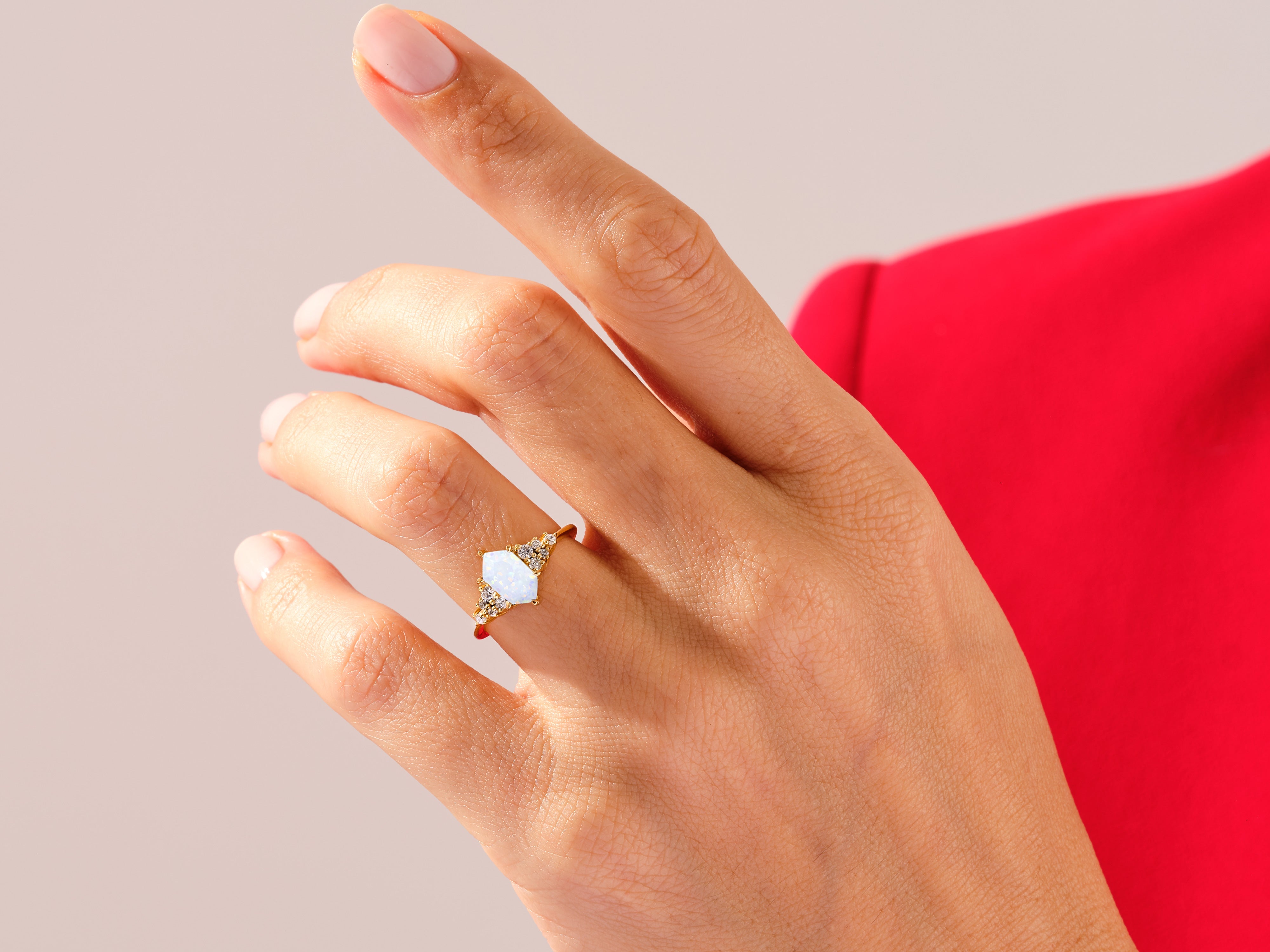 Gold ring with opal and diamonds on a woman's hand