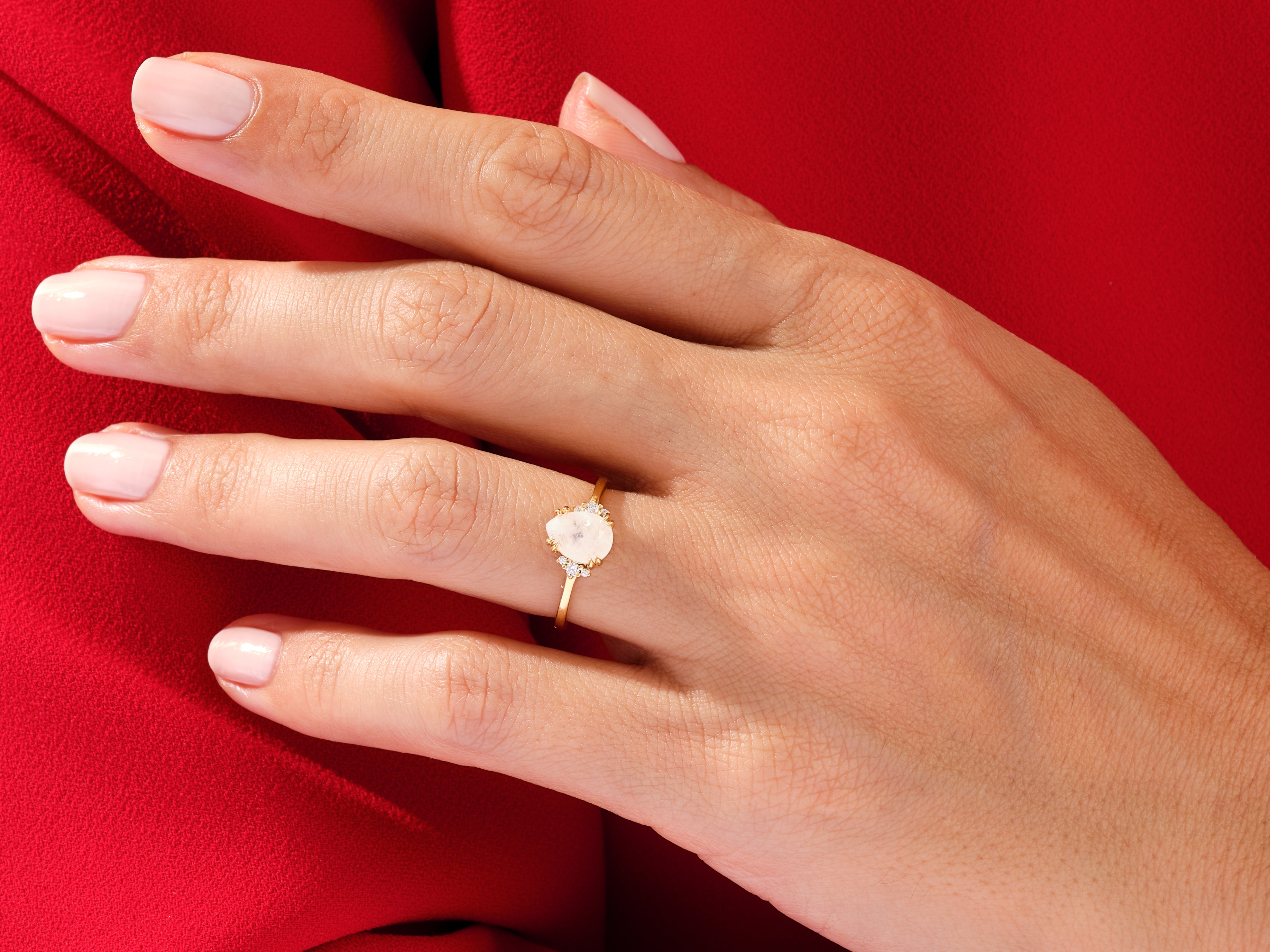 Gold ring with moonstone and diamonds on a hand