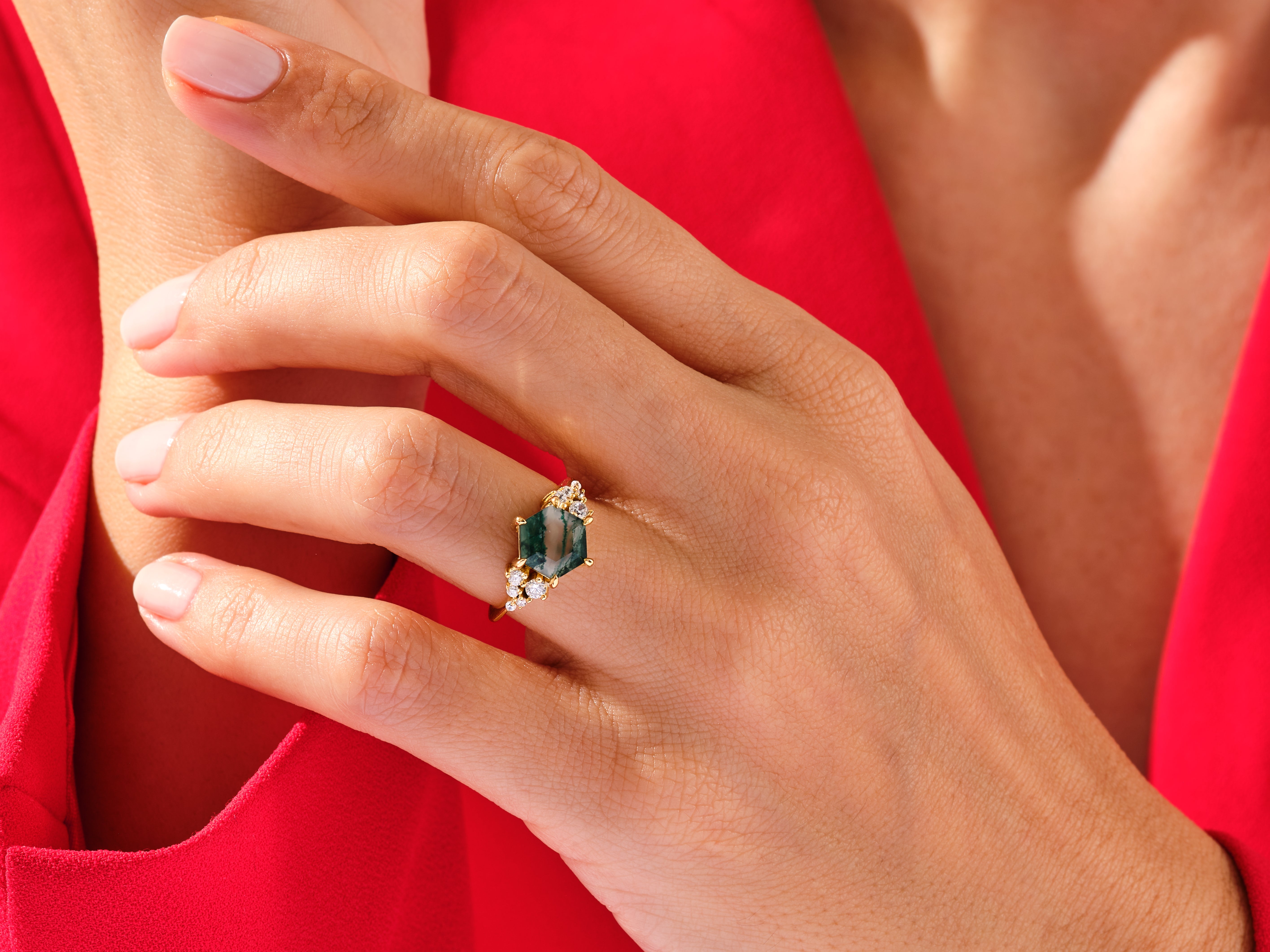 Gold ring with green gemstone and diamonds on hand