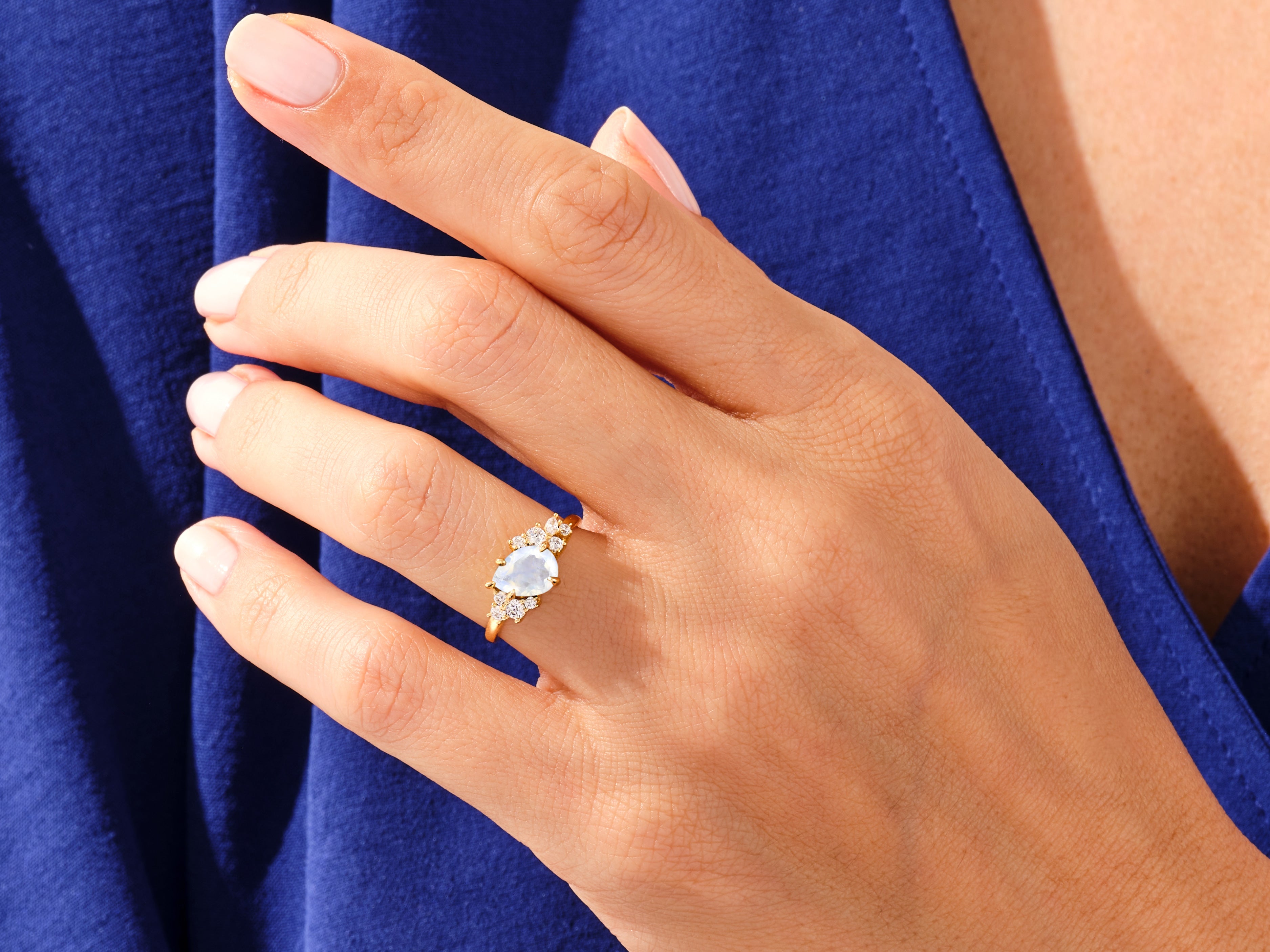 Gold ring with moonstone and diamonds on a woman's finger