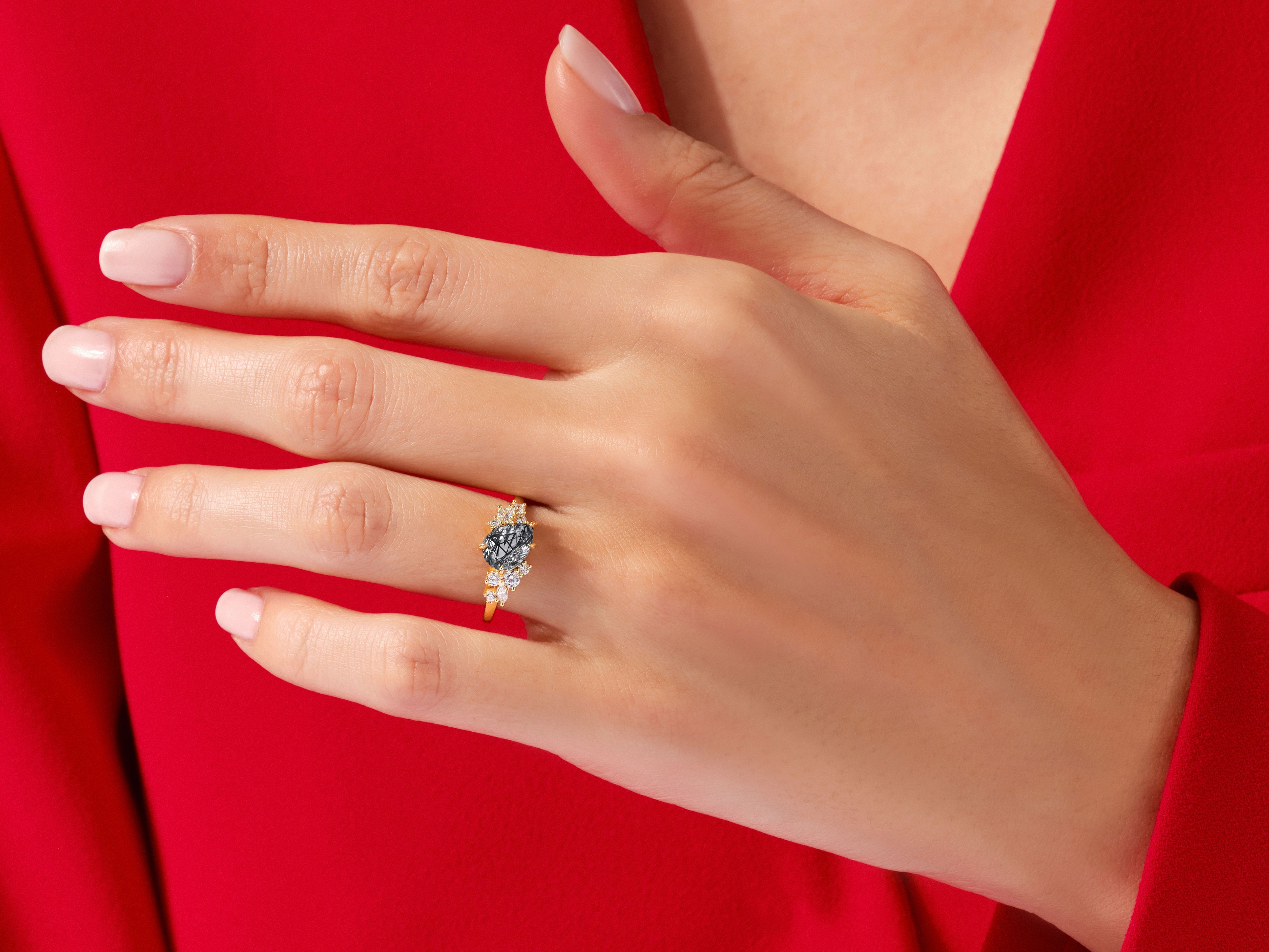 Gold ring with black and white stones on a hand