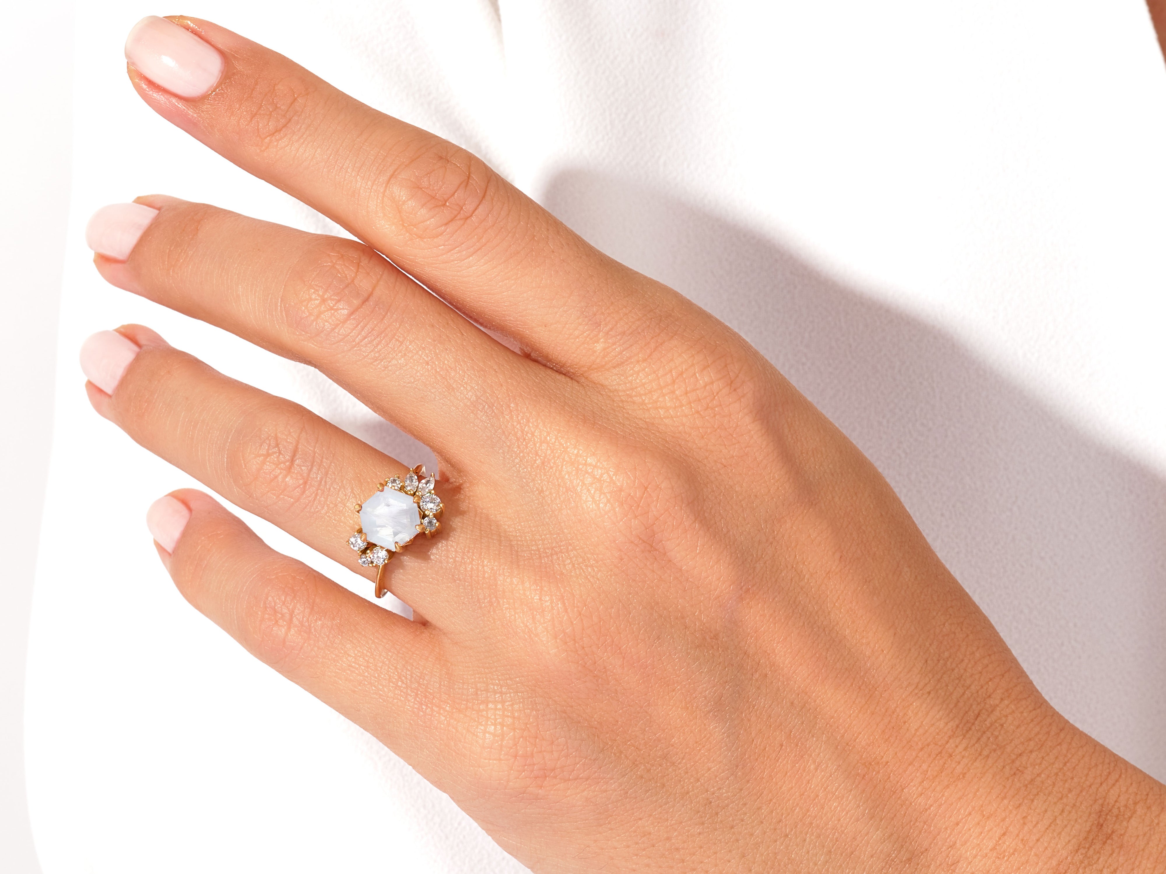 Gold ring with moonstone and diamonds on a woman's hand