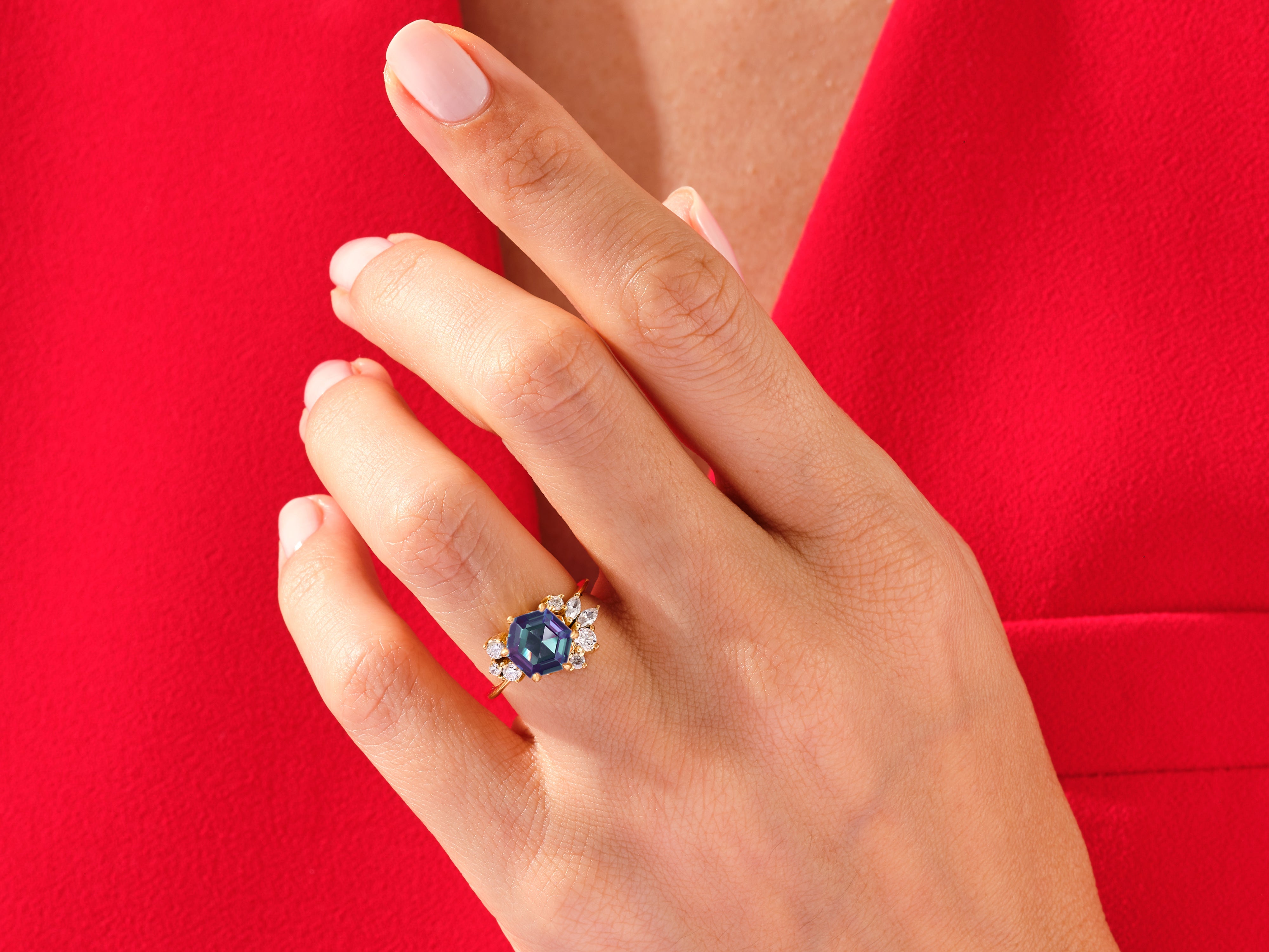 Jewelry: Hexagonal gemstone ring with diamonds on a red background