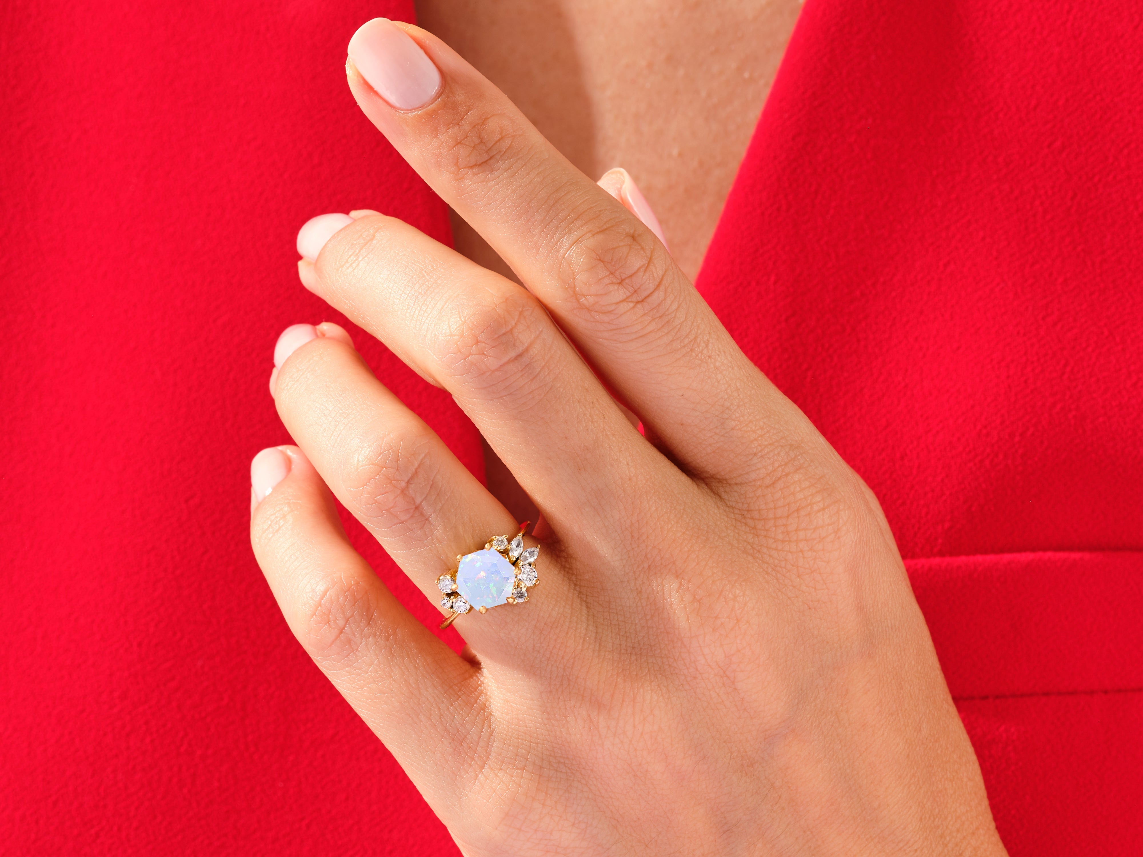 Opal and diamond engagement ring on a hand