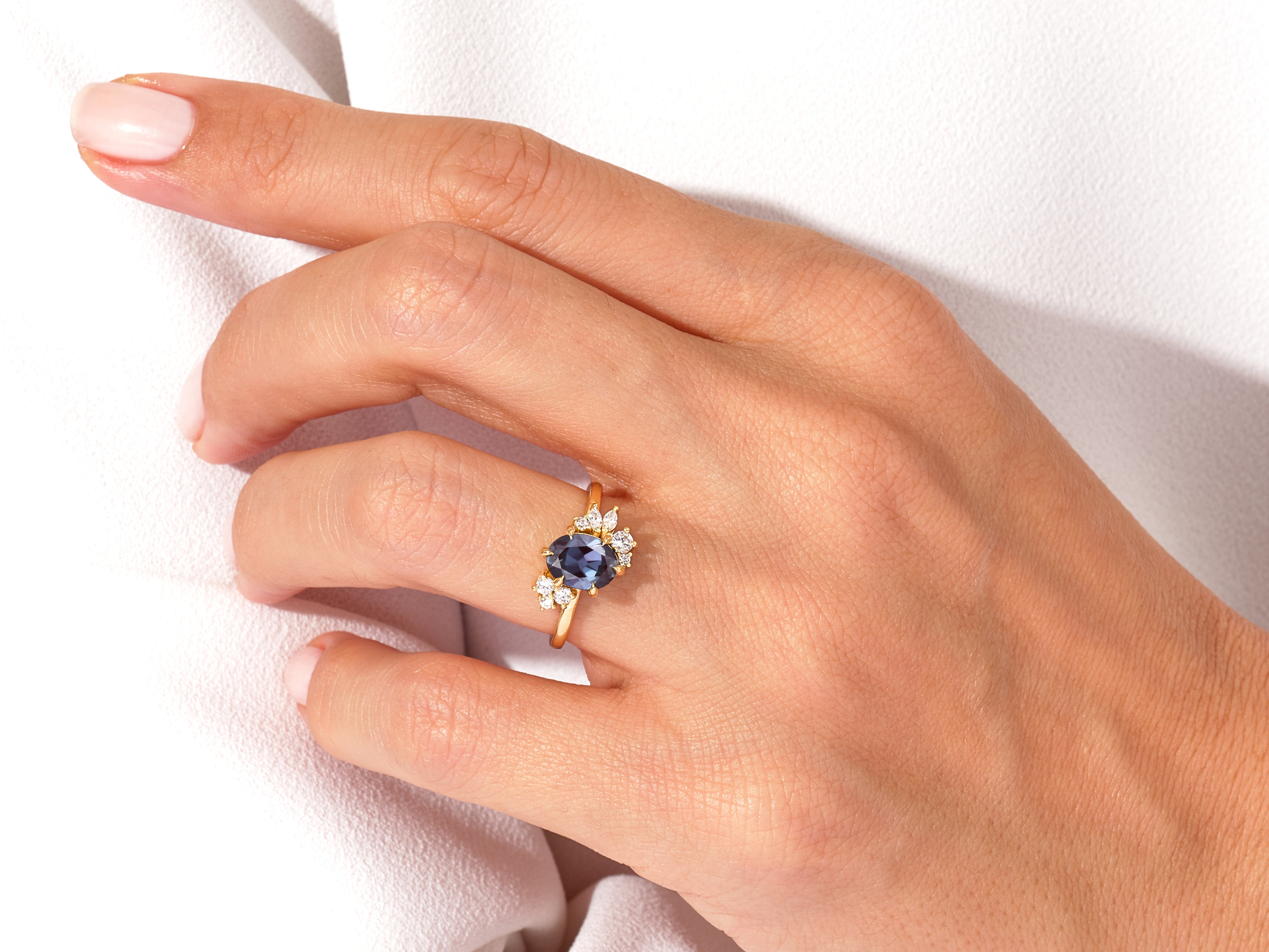 Oval sapphire and diamond engagement ring on hand