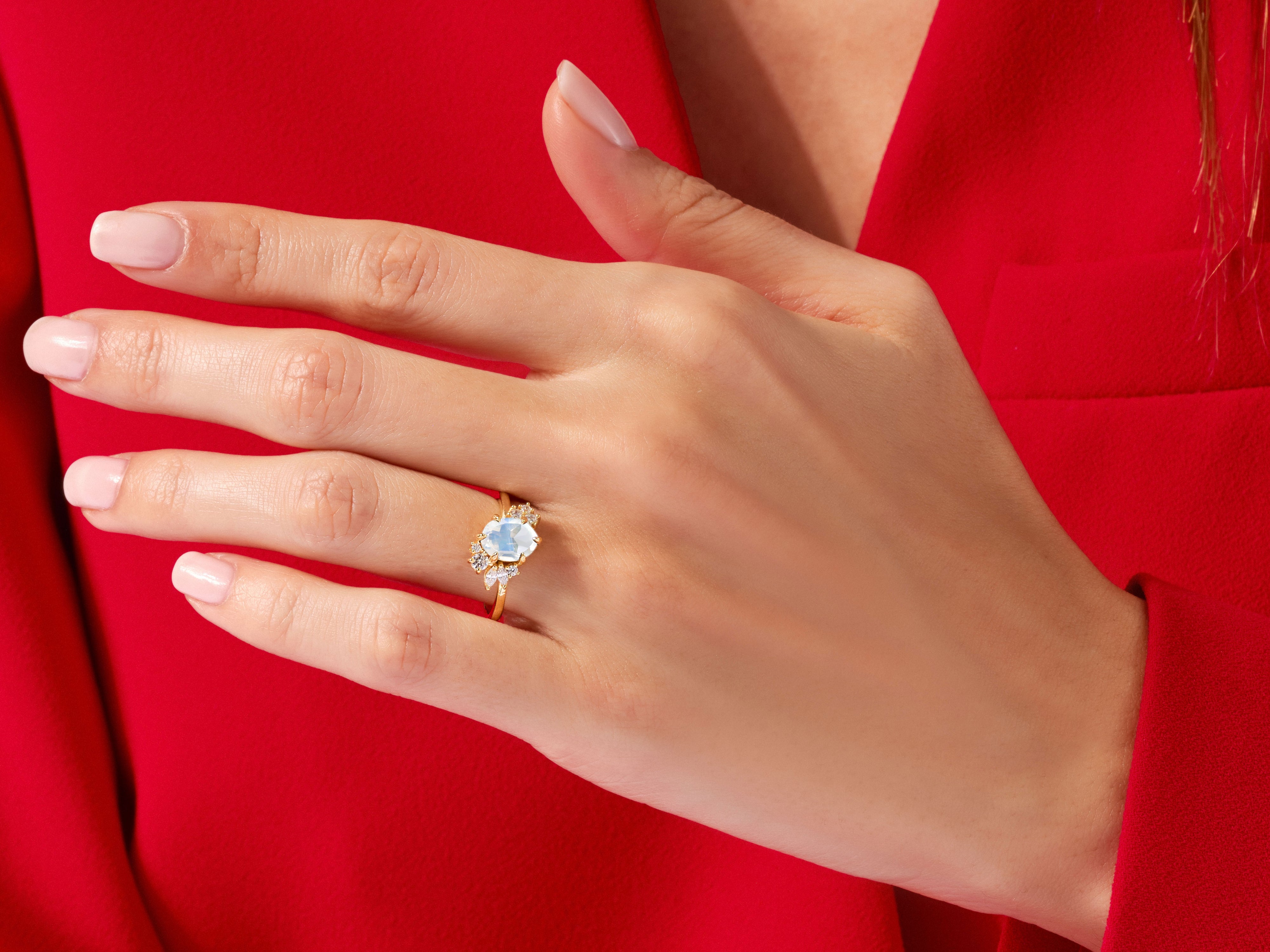 Gold ring with blue gemstone and diamonds on a hand