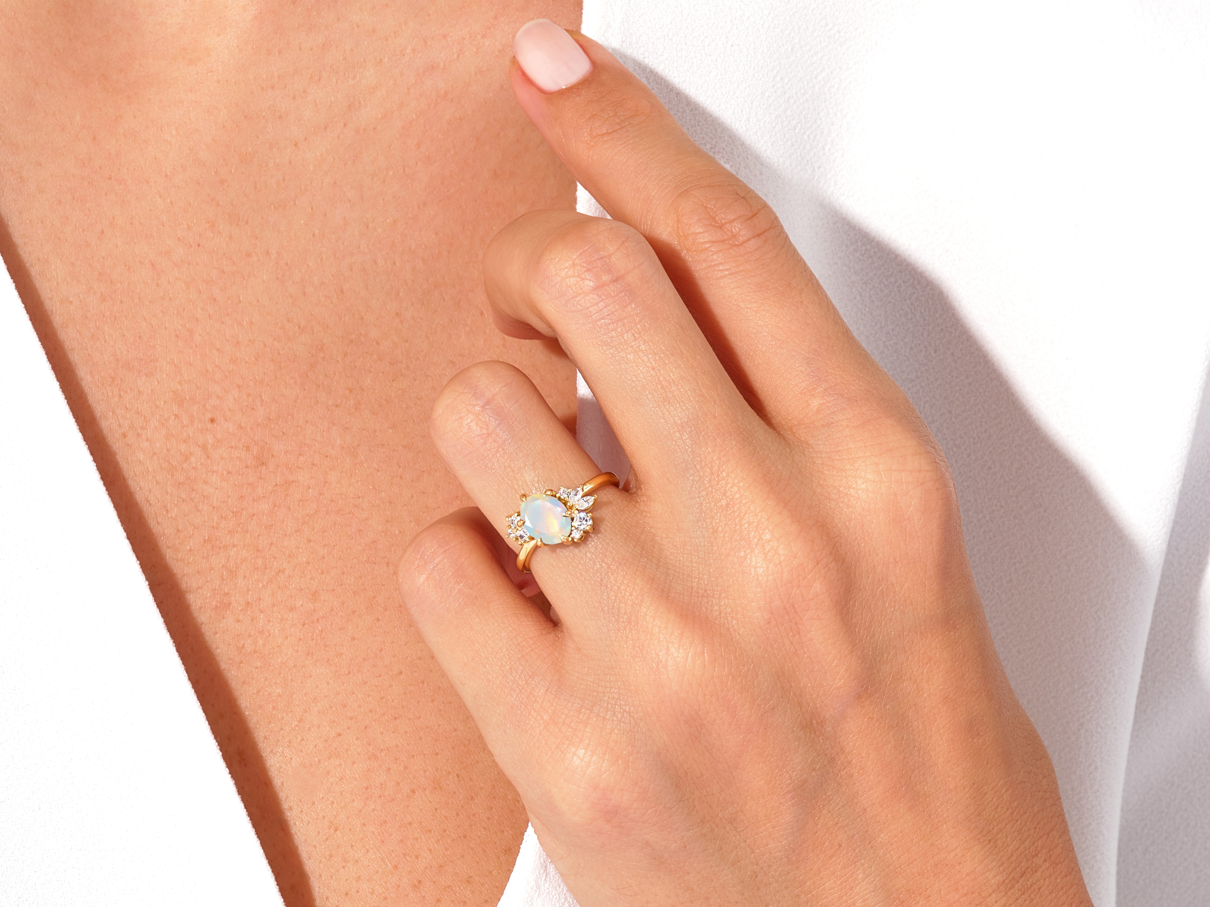 Gold opal ring with diamonds on a woman's hand