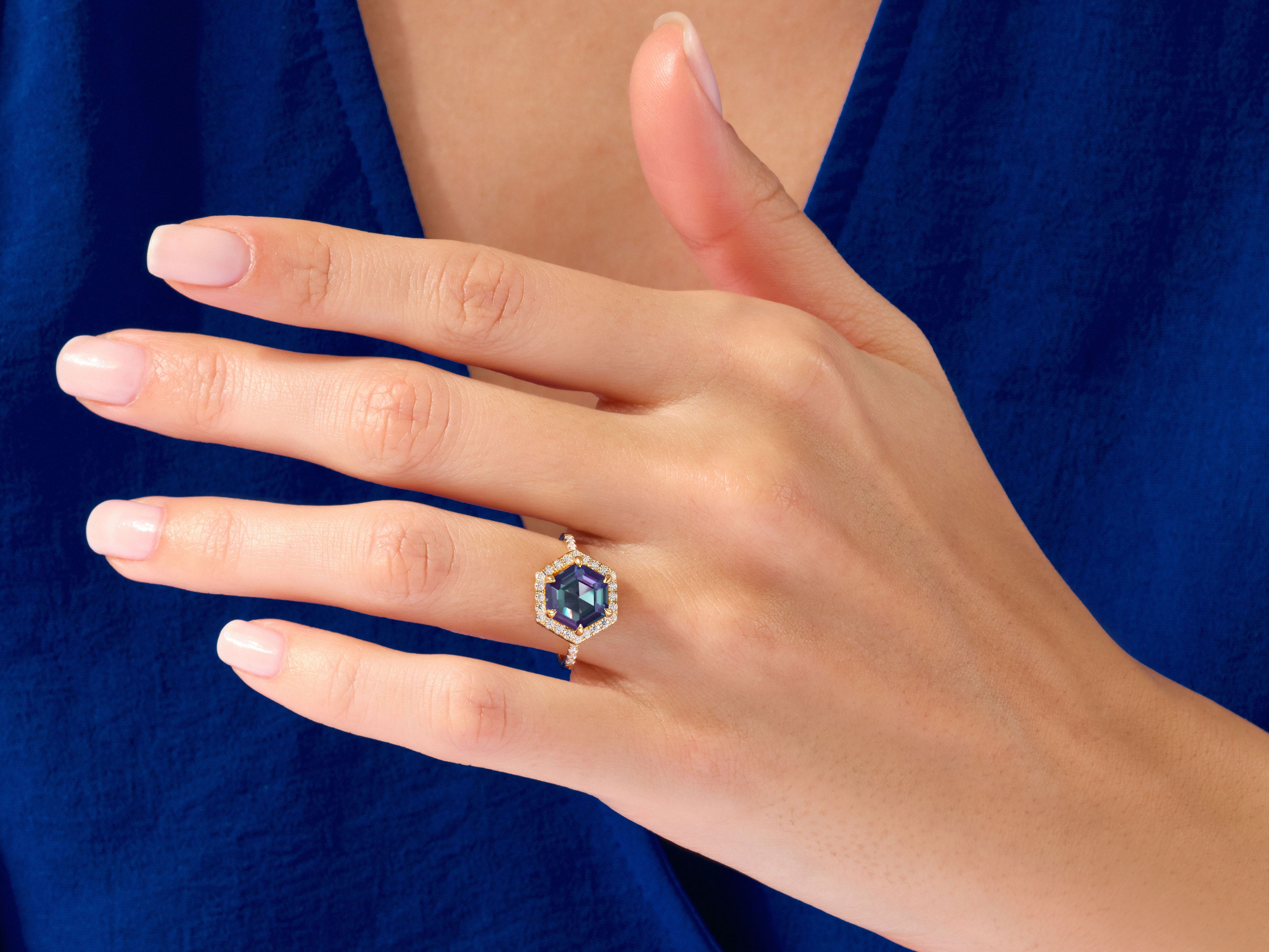 Hexagonal gemstone ring with diamonds on a hand