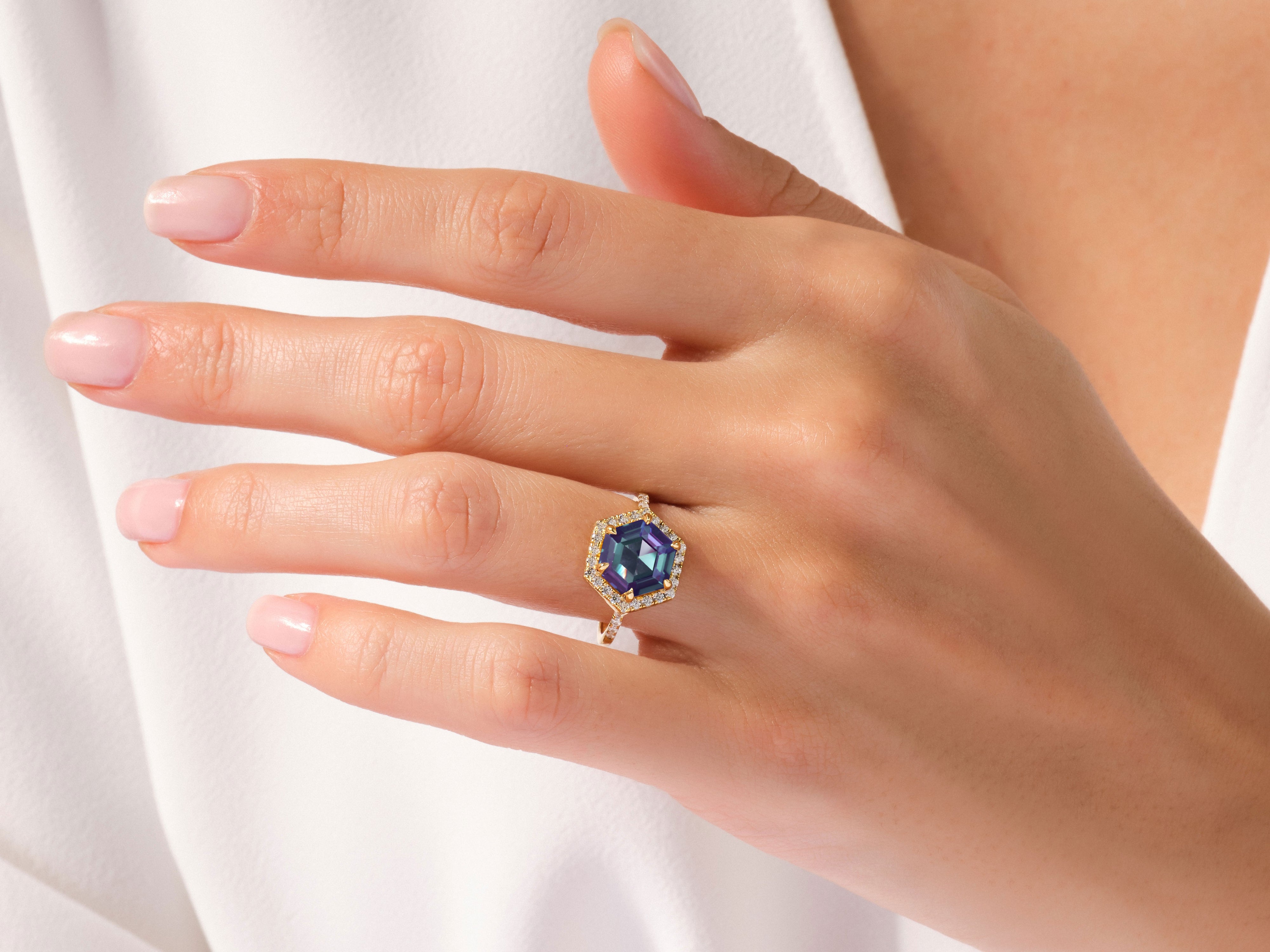 Hexagonal alexandrite ring with diamonds on a woman's hand