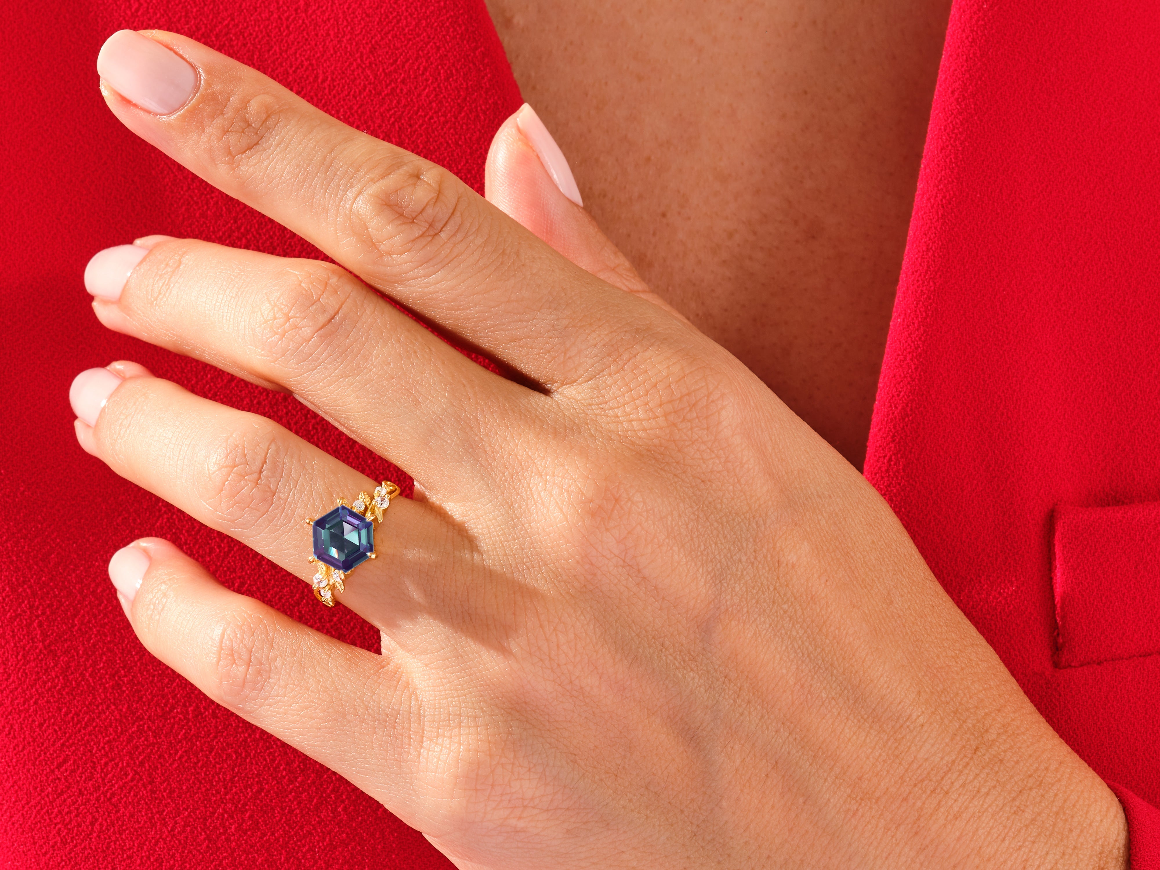 Gold ring with hexagon gemstone and diamonds on hand