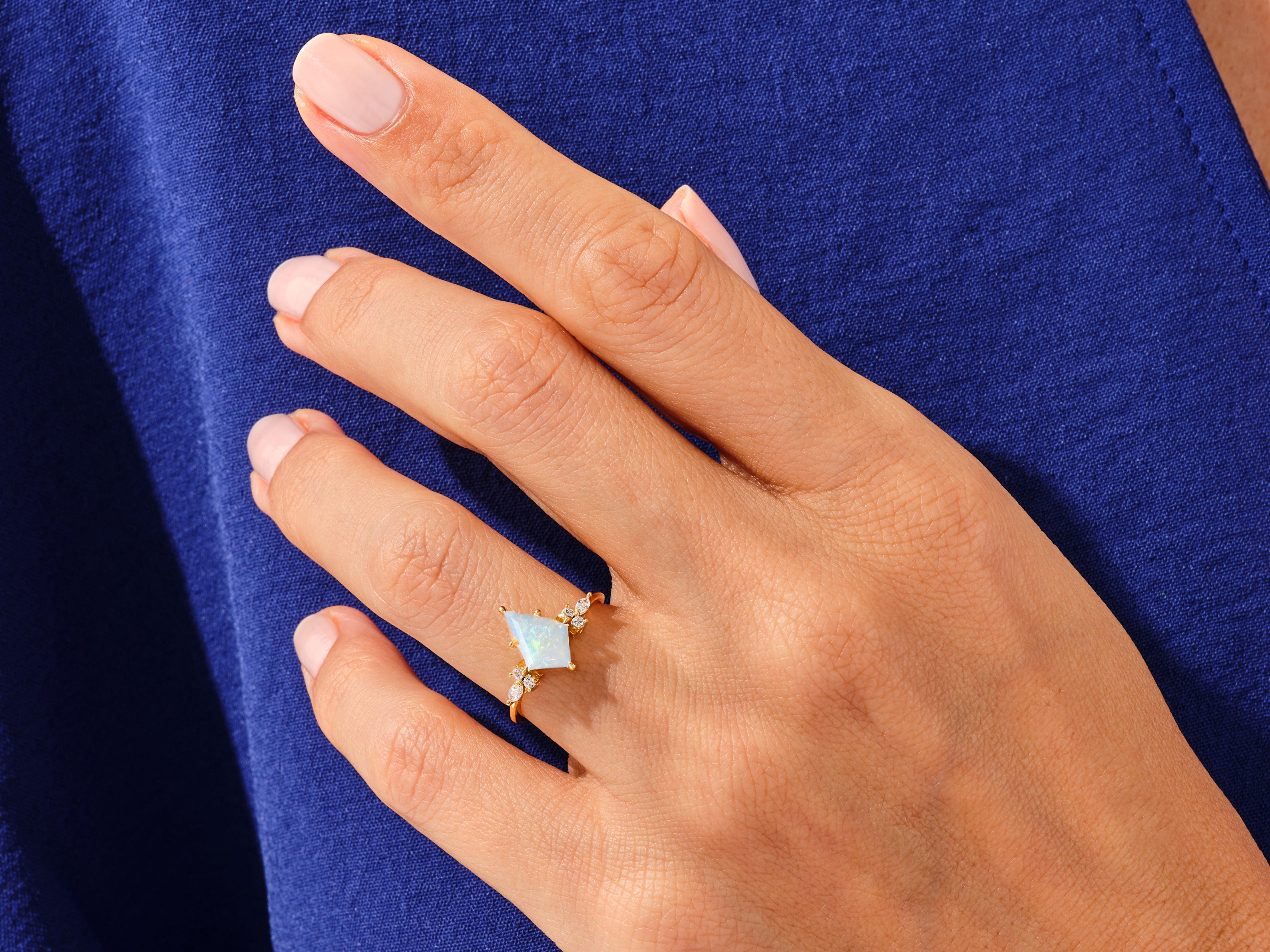 Gold opal ring with diamonds on a woman's hand