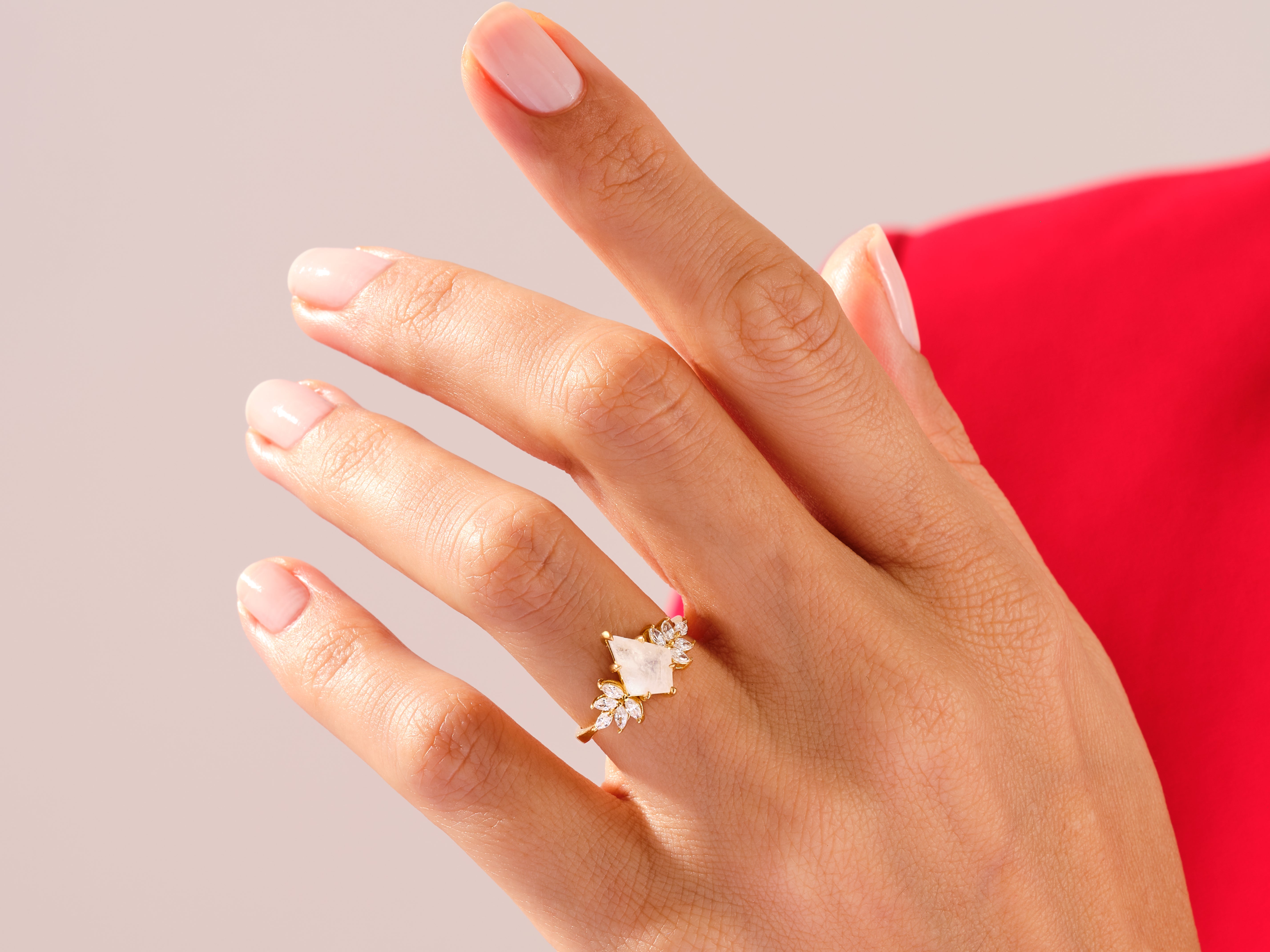 Gold ring with white gemstone and diamonds on a hand