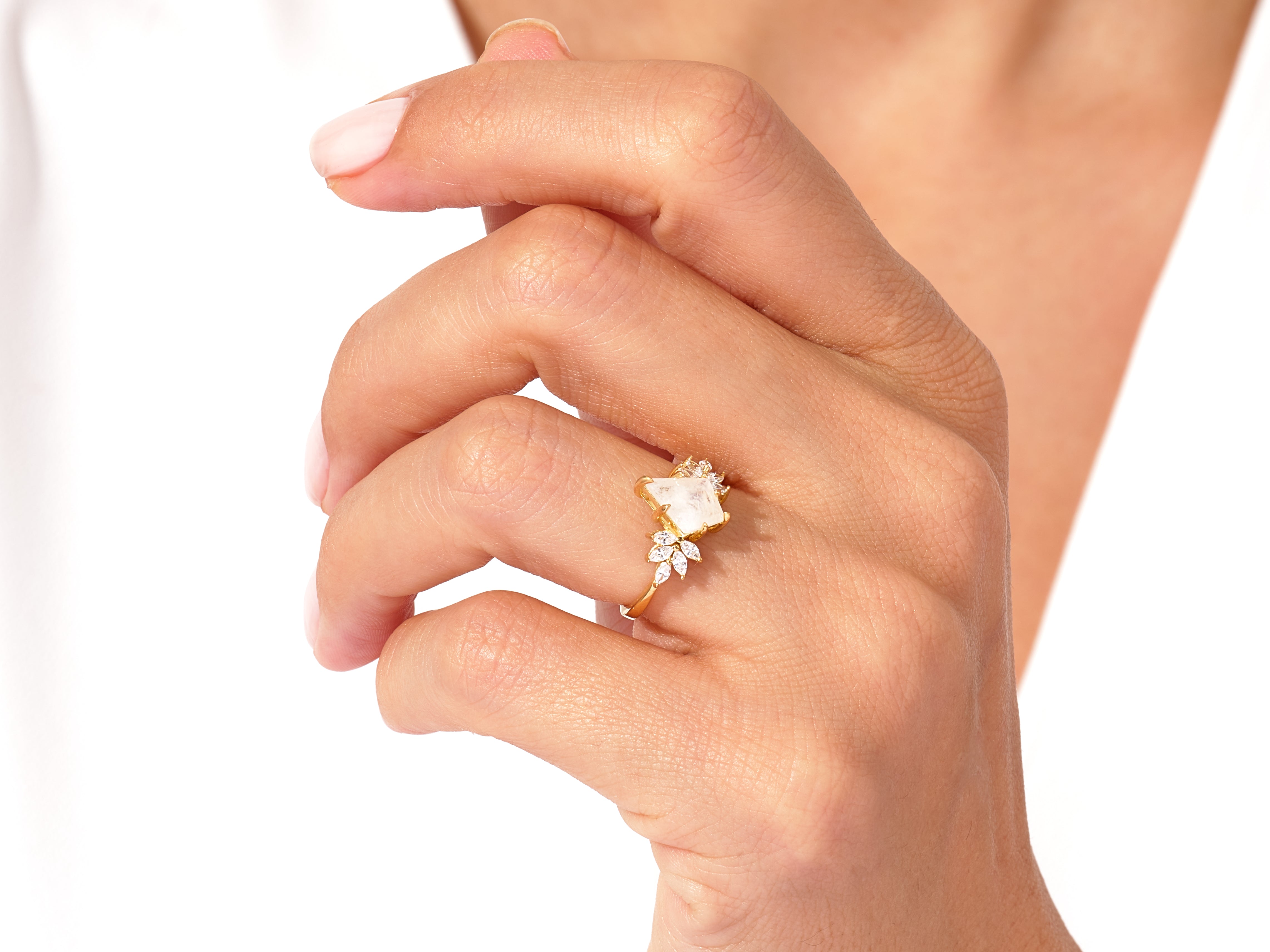 Gold ring with moonstone and diamonds on a woman's hand