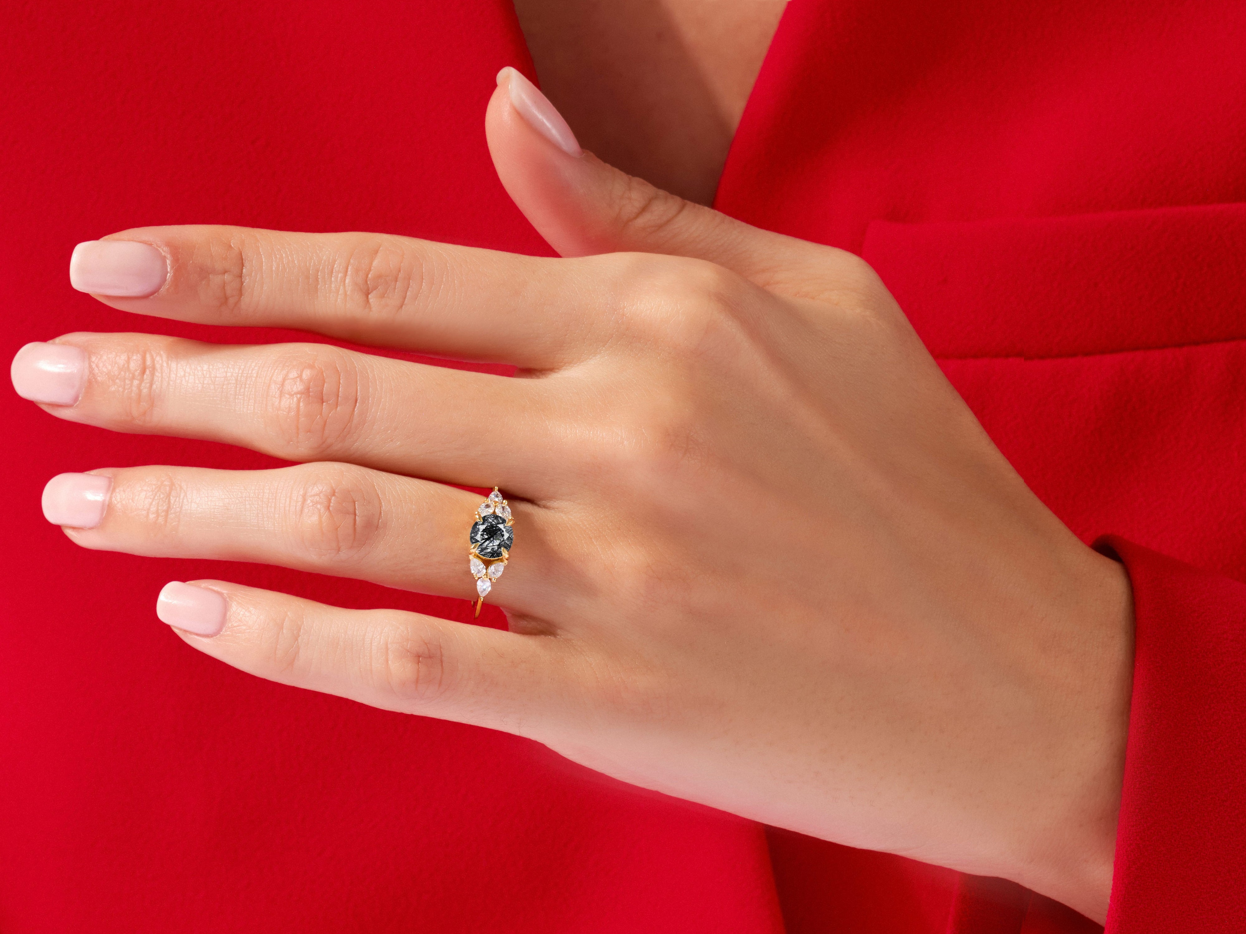 Gold ring with black and white diamonds on a hand