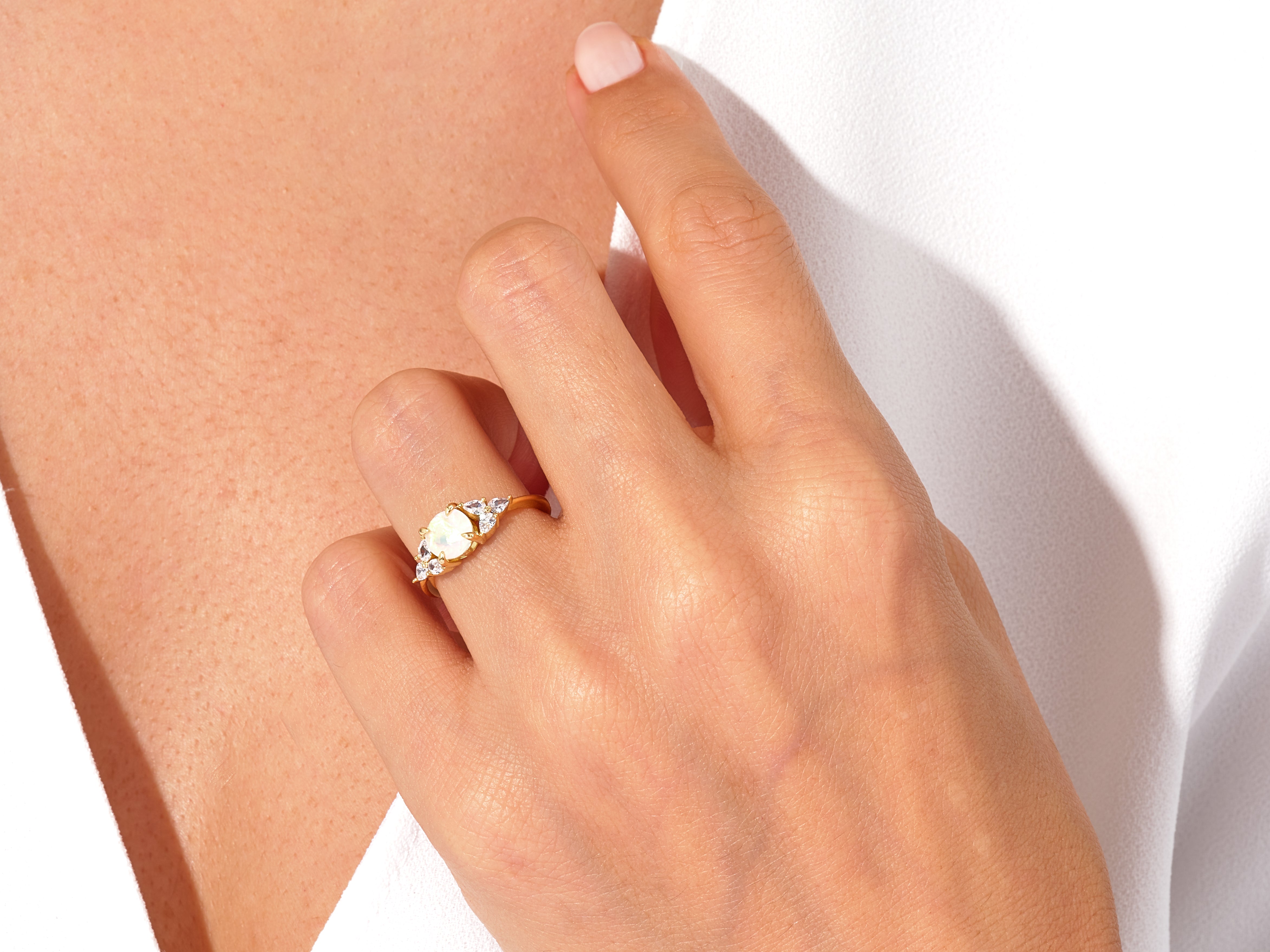 Gold opal ring with diamonds on a hand