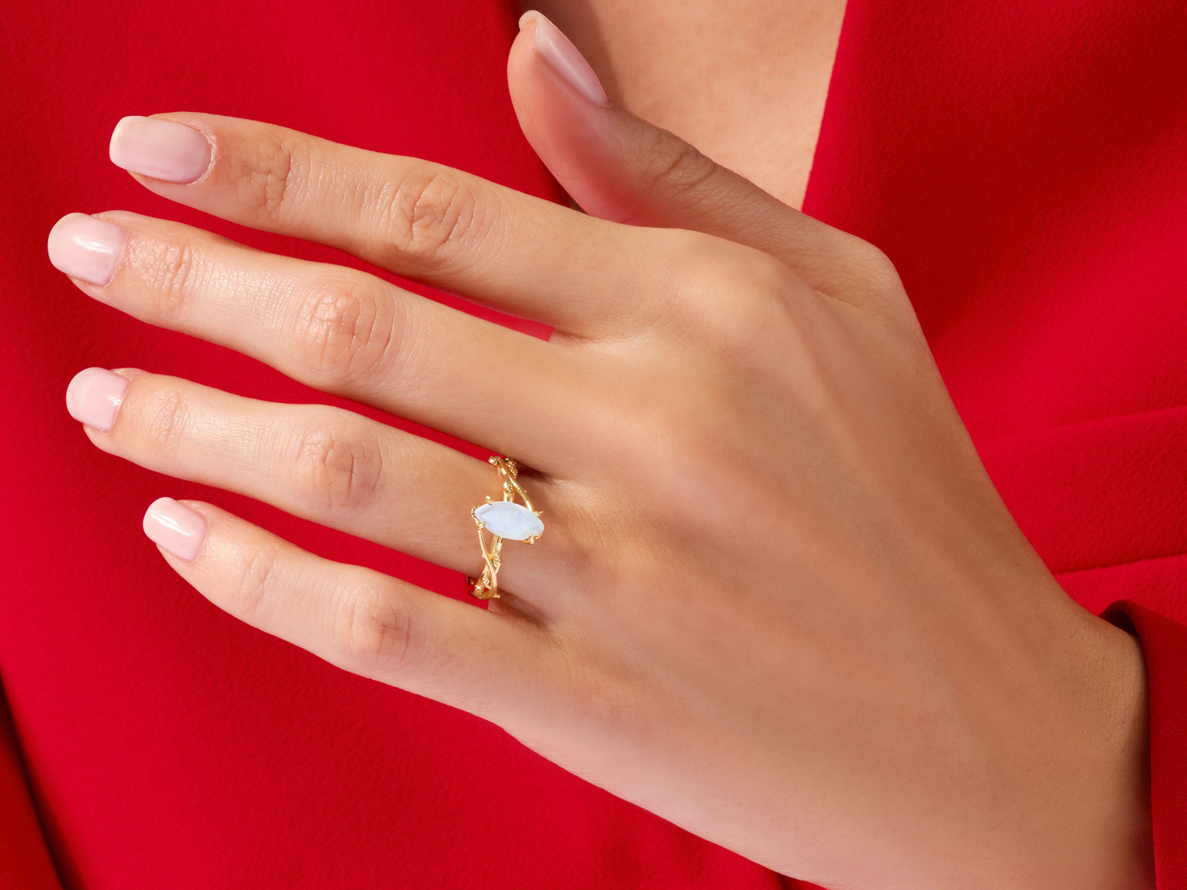 Gold ring with opal gemstone on a woman's hand