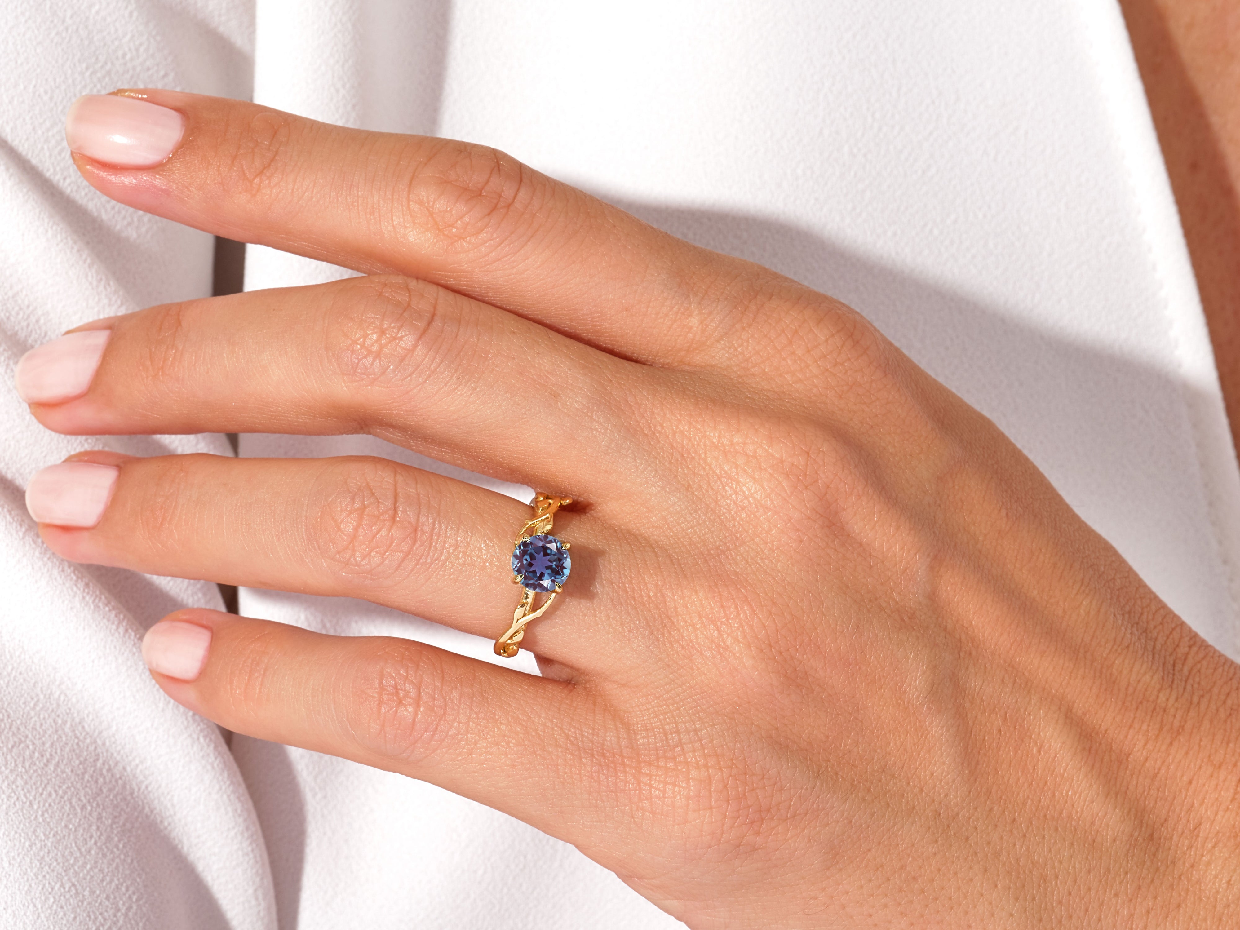Gold ring with blue gemstone on a hand