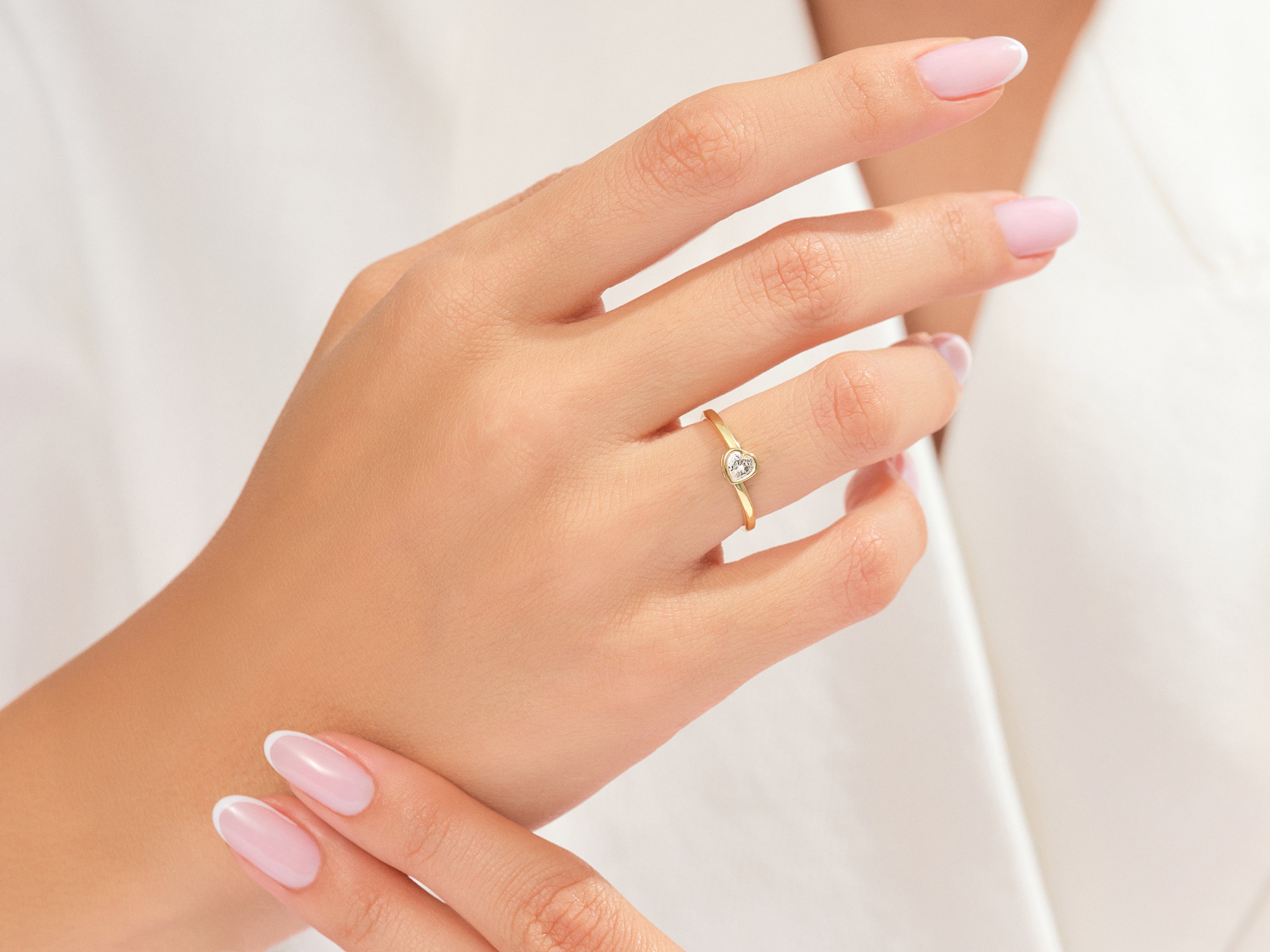 Gold heart ring with diamond on elegant hand
