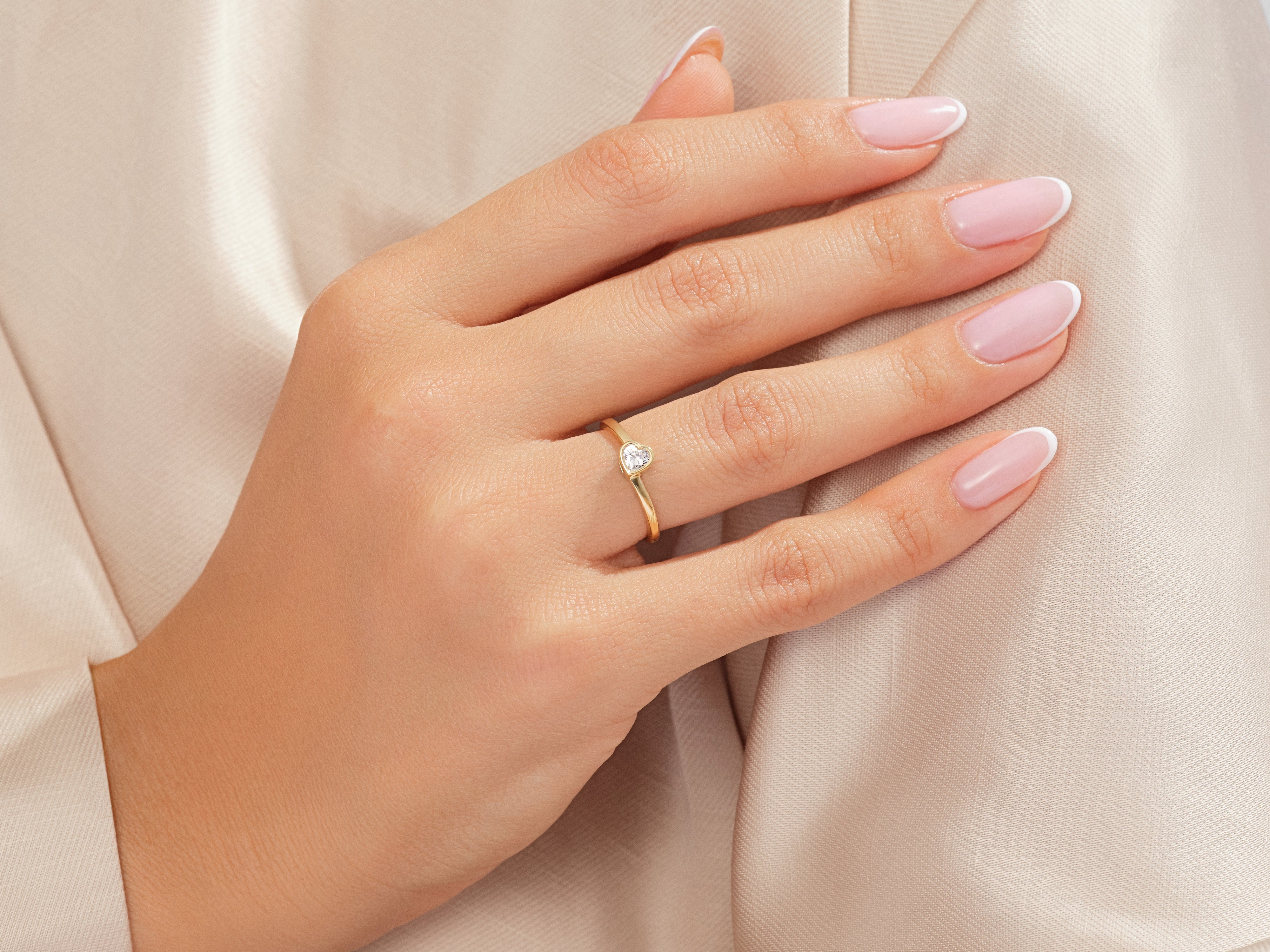 Gold heart diamond ring on elegant hand