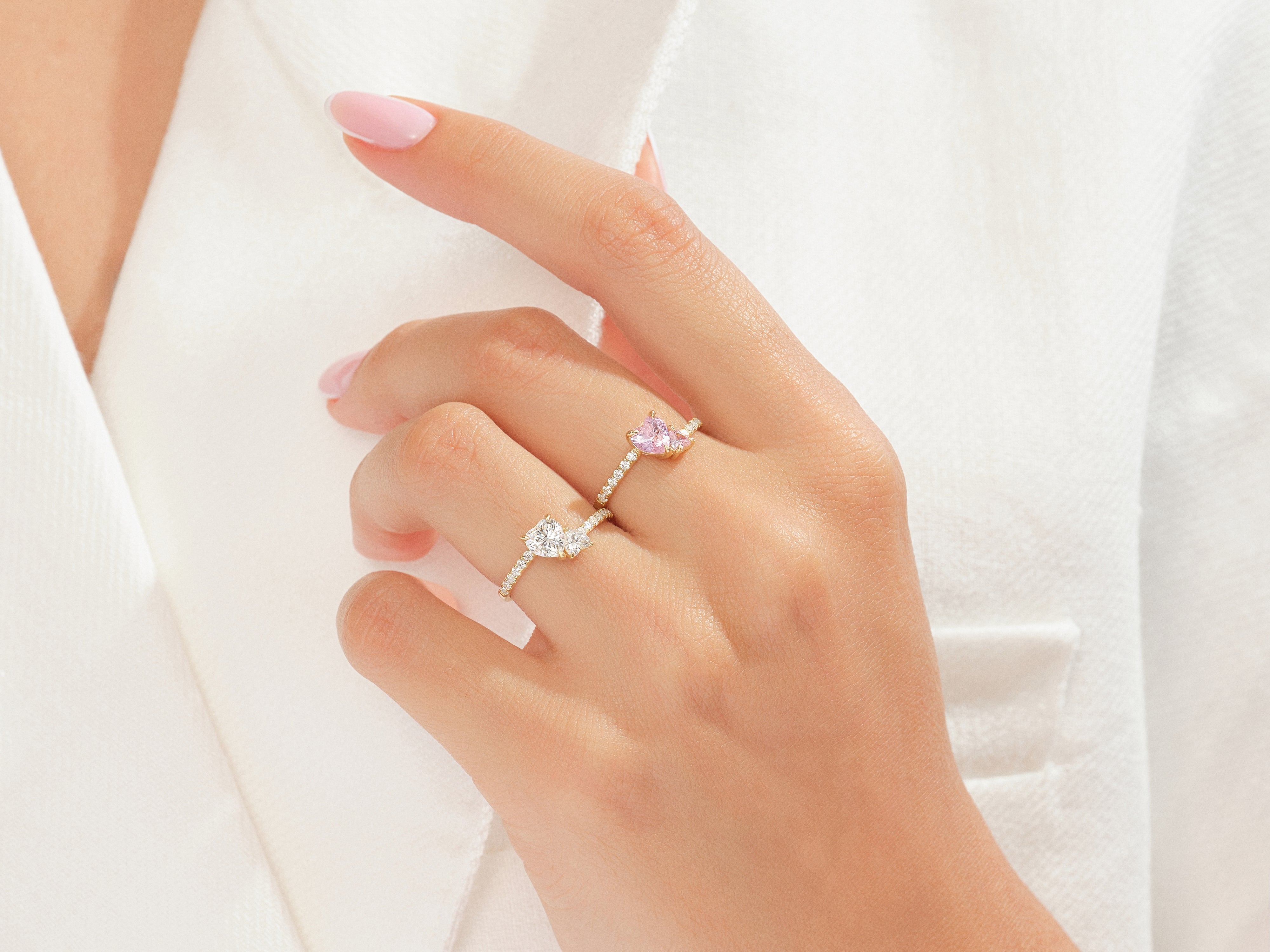 Diamond and pink sapphire rings on a hand, fine jewelry