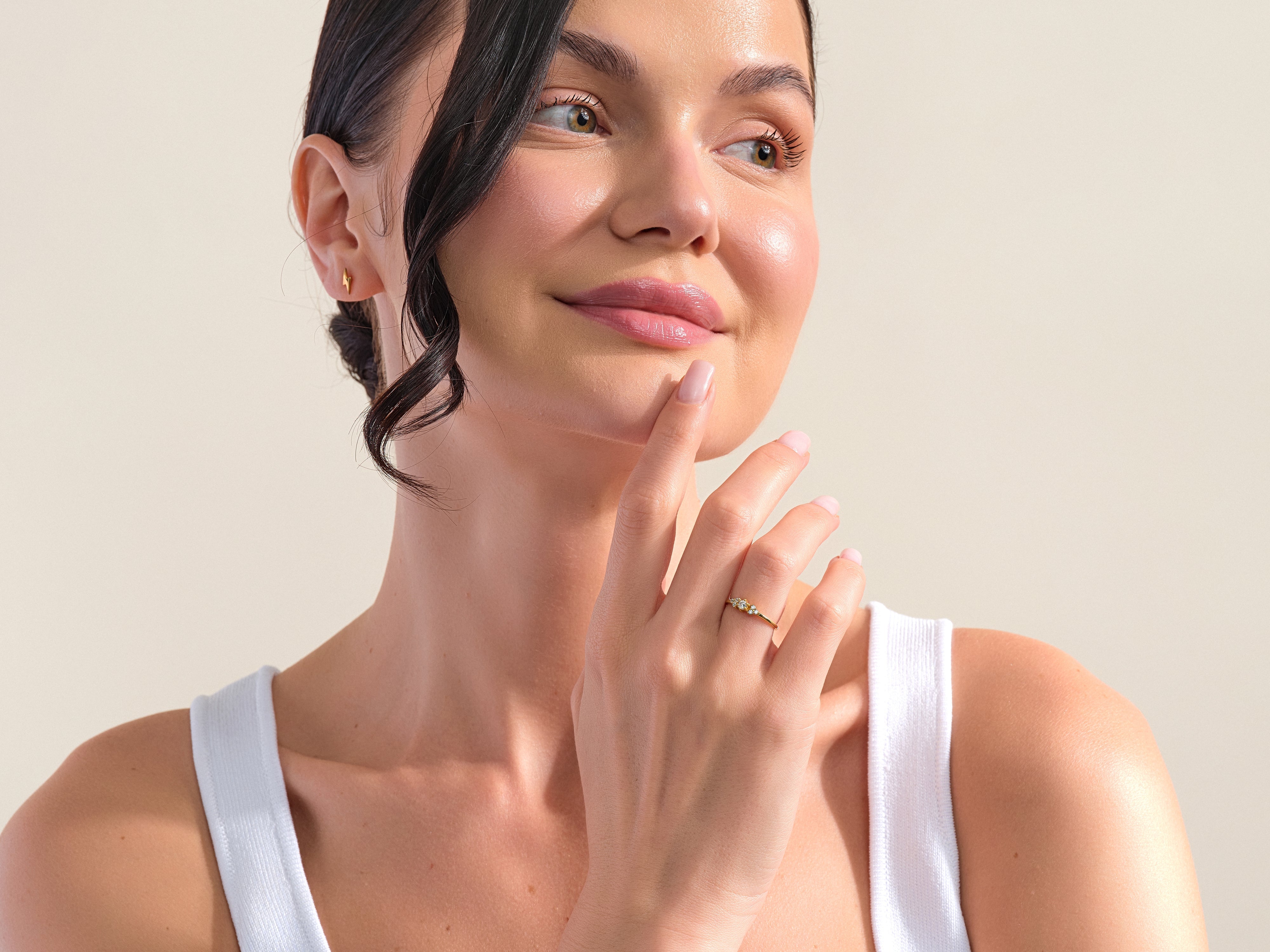 Woman wearing a gold diamond ring and stud earring, jewelry photography