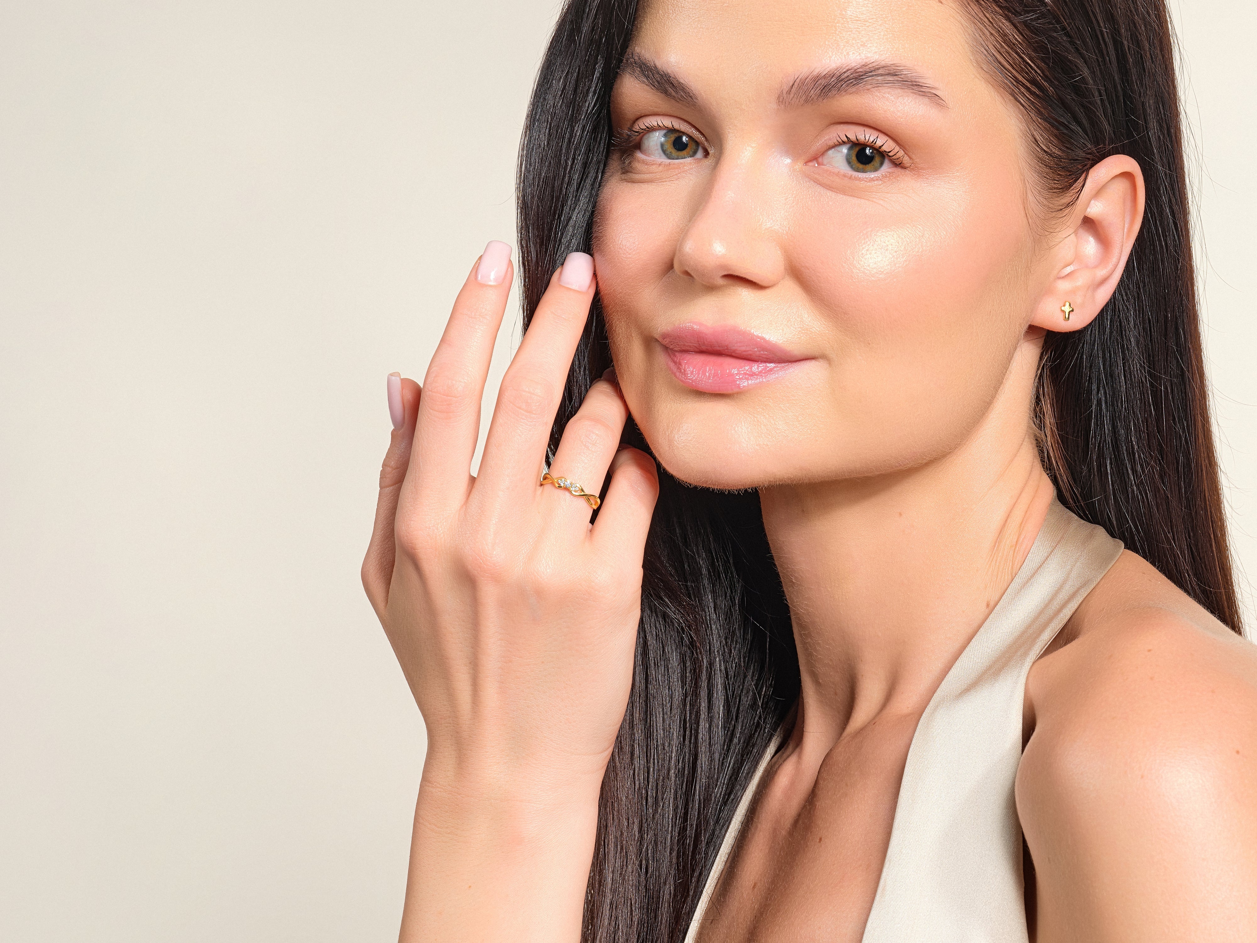 Elegant woman wearing a diamond ring and gold stud earrings