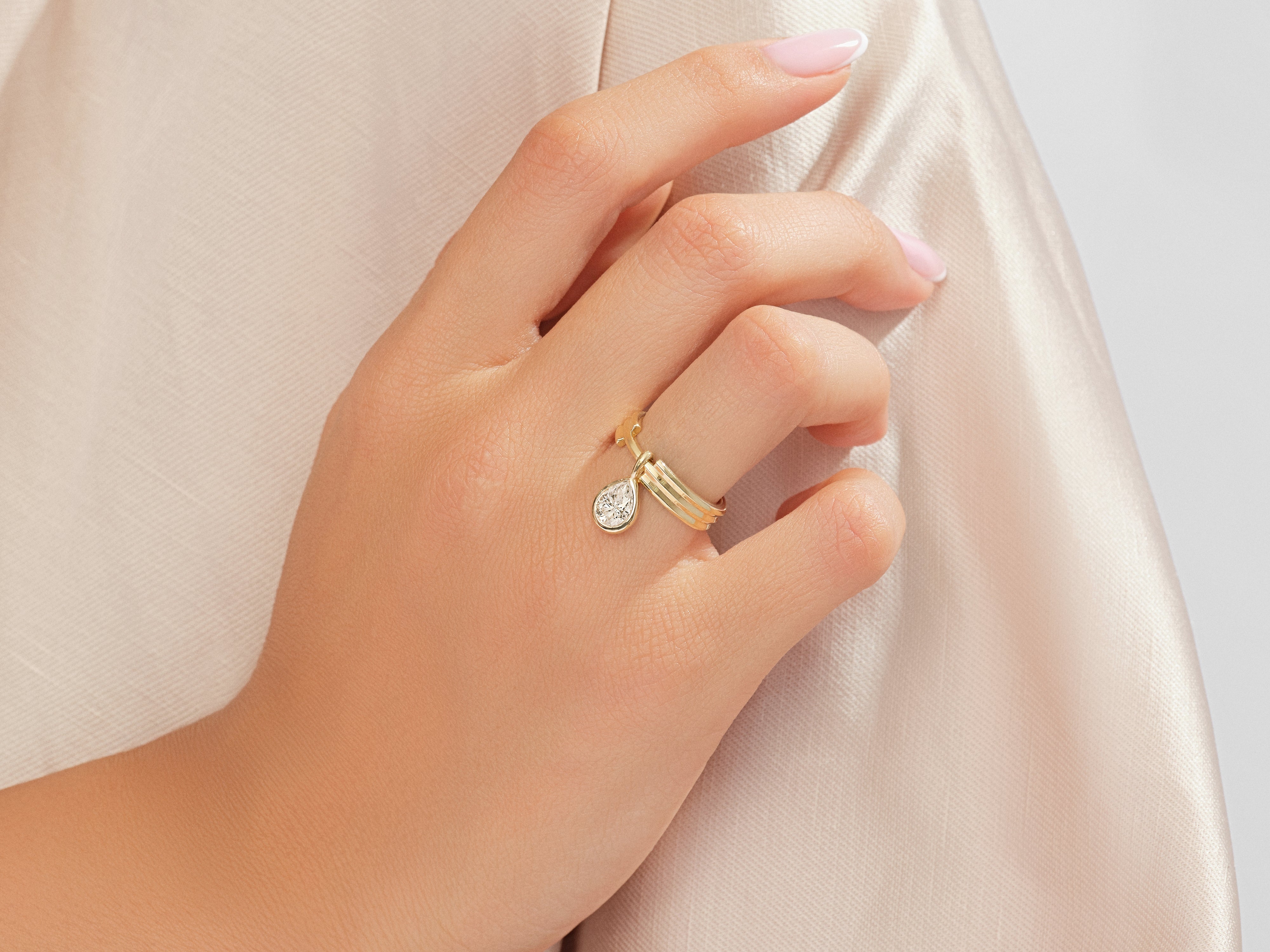 Gold ring with diamond pendant on a woman's hand