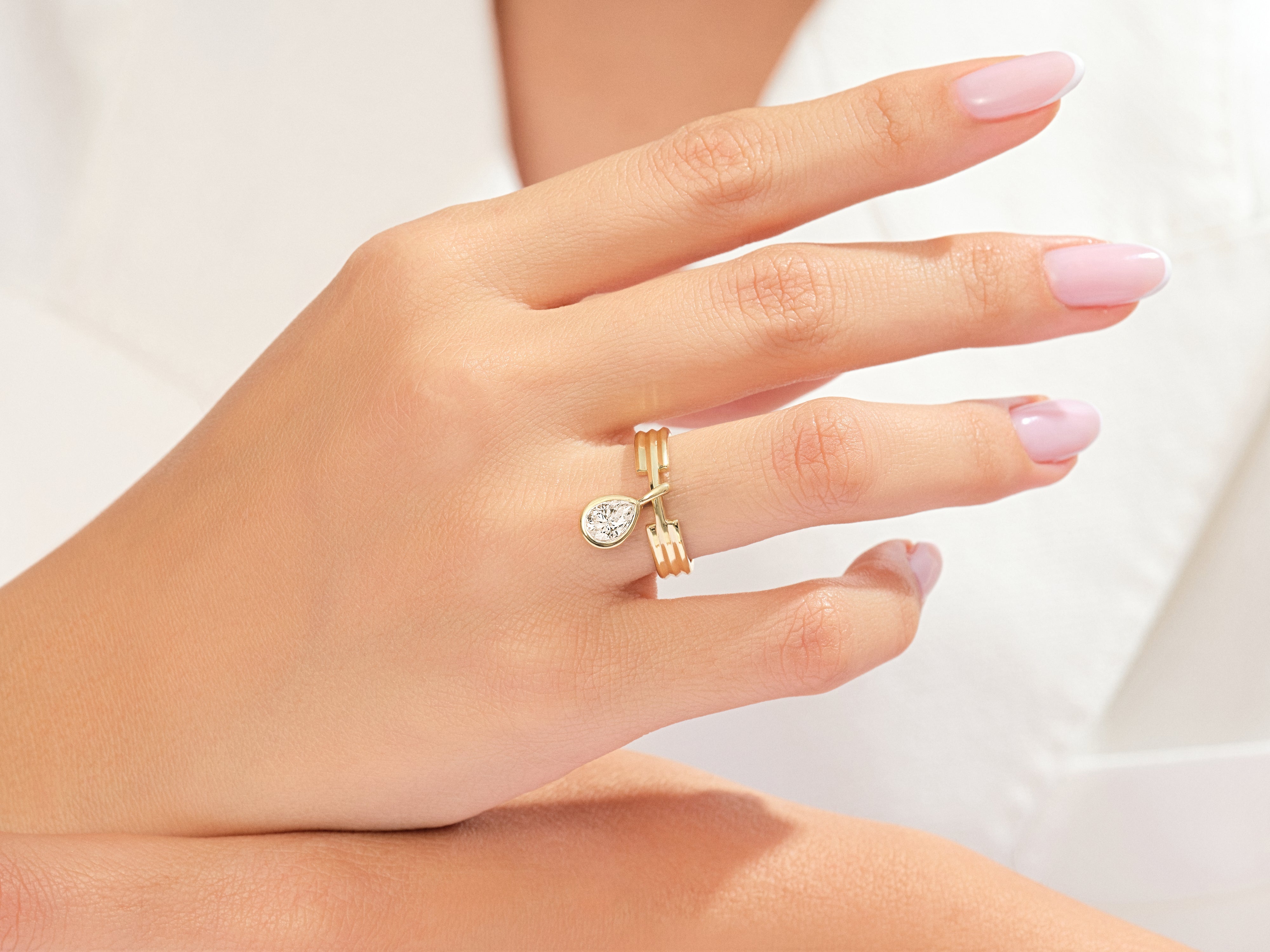Gold ring with pear-shaped diamond on a woman's hand