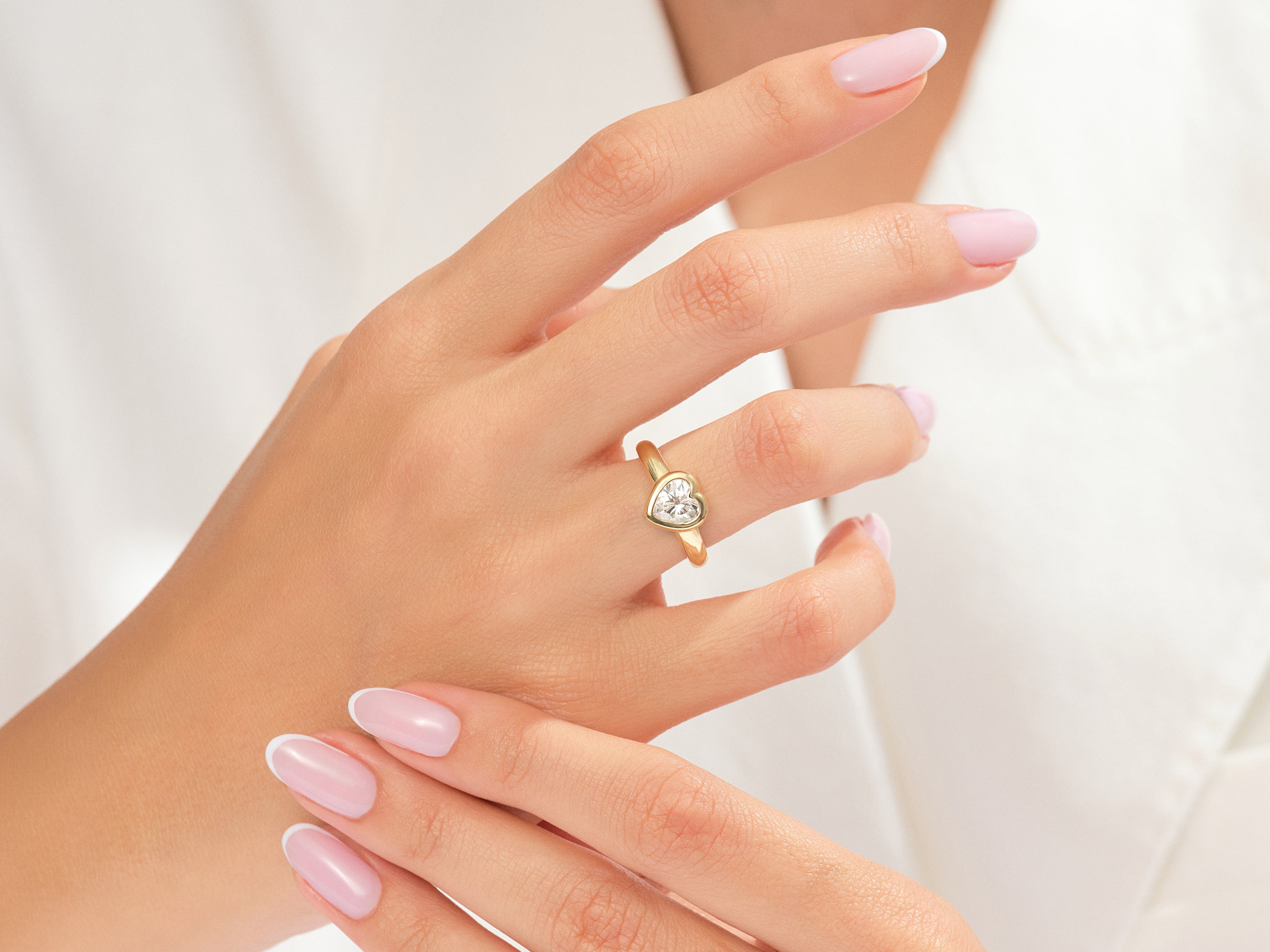 Gold heart diamond ring on a woman's finger