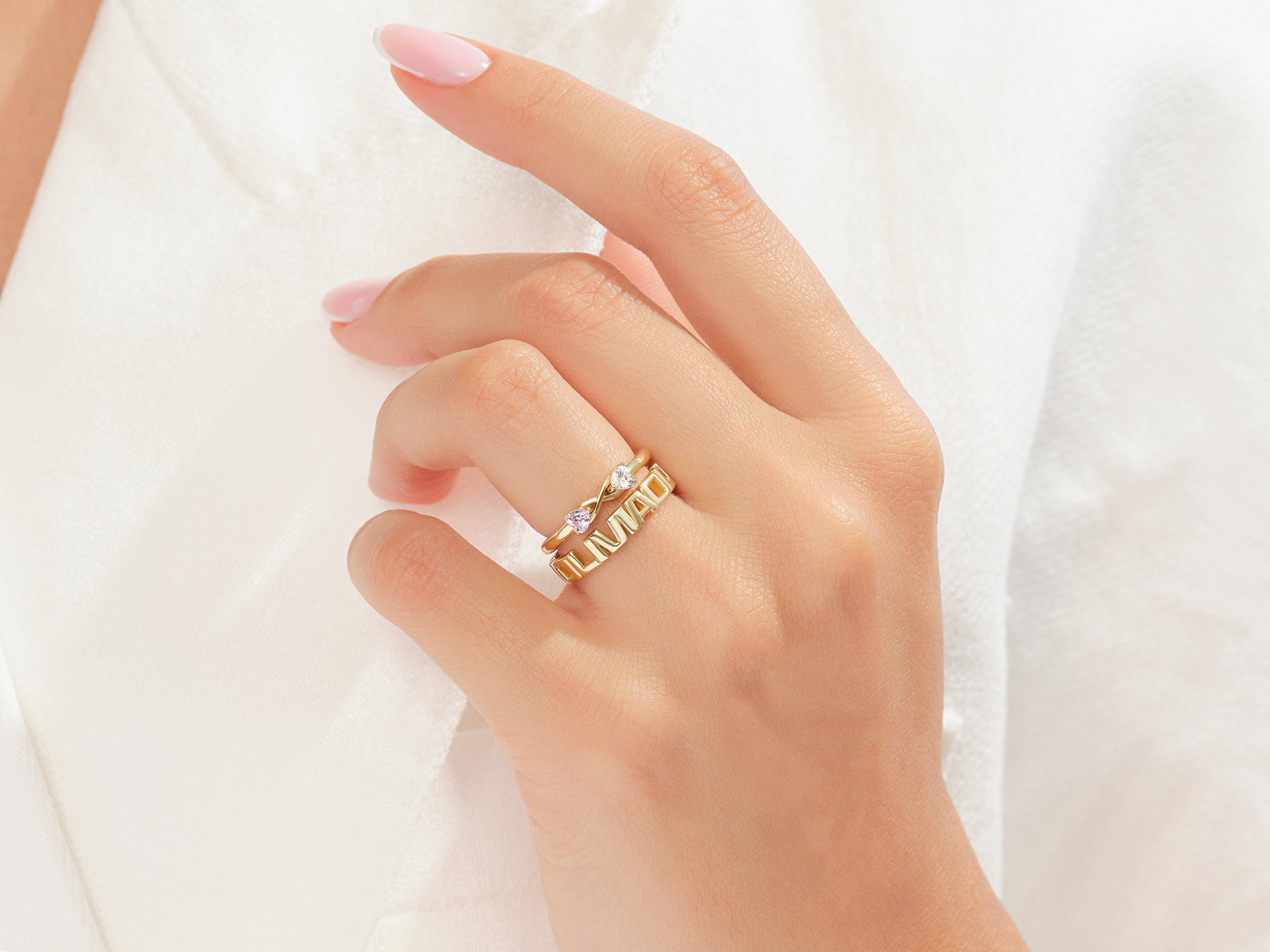 Gold rings with diamonds and pink stones on a hand