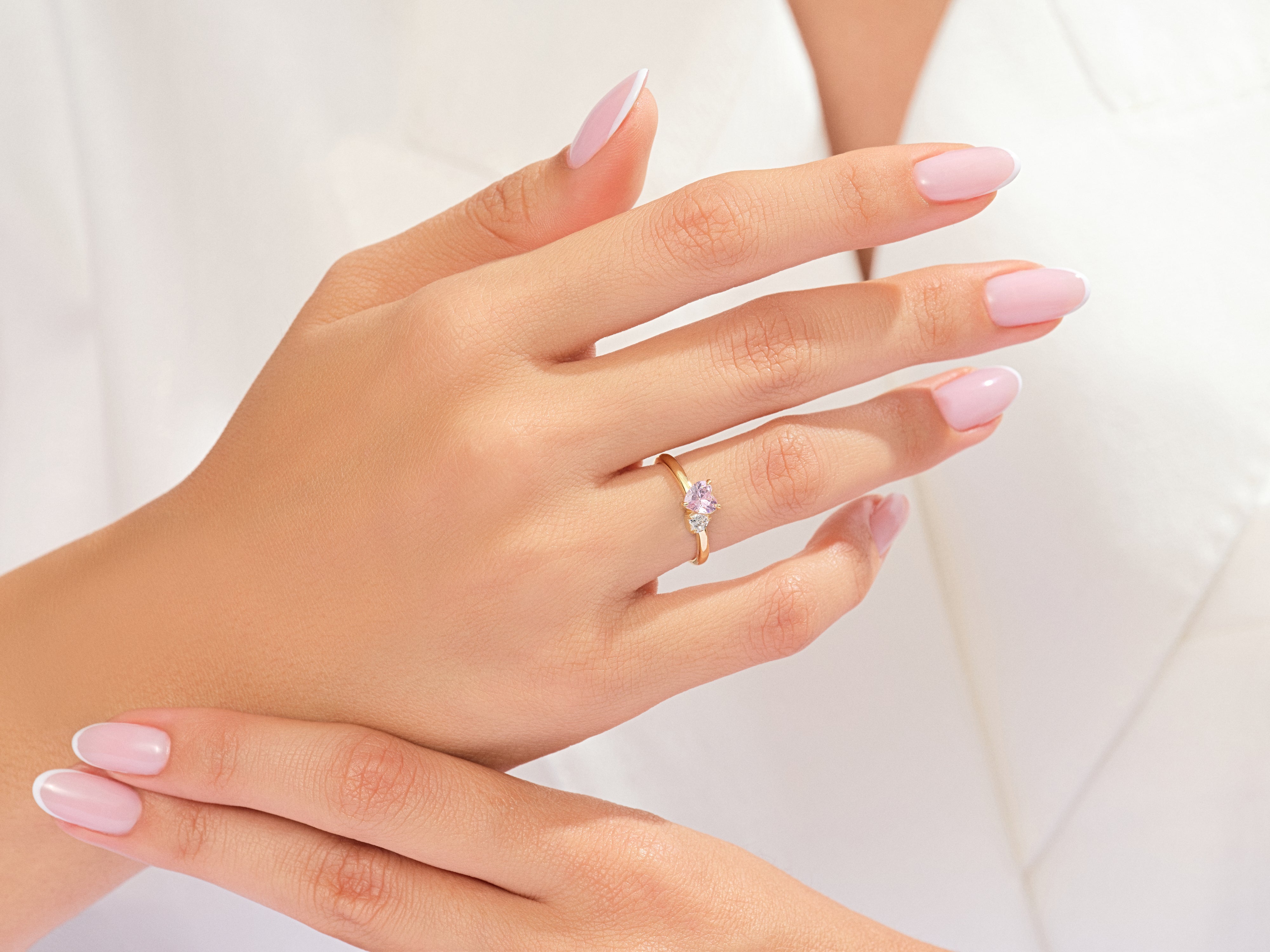 Gold ring with pink and white stones on a woman's hand