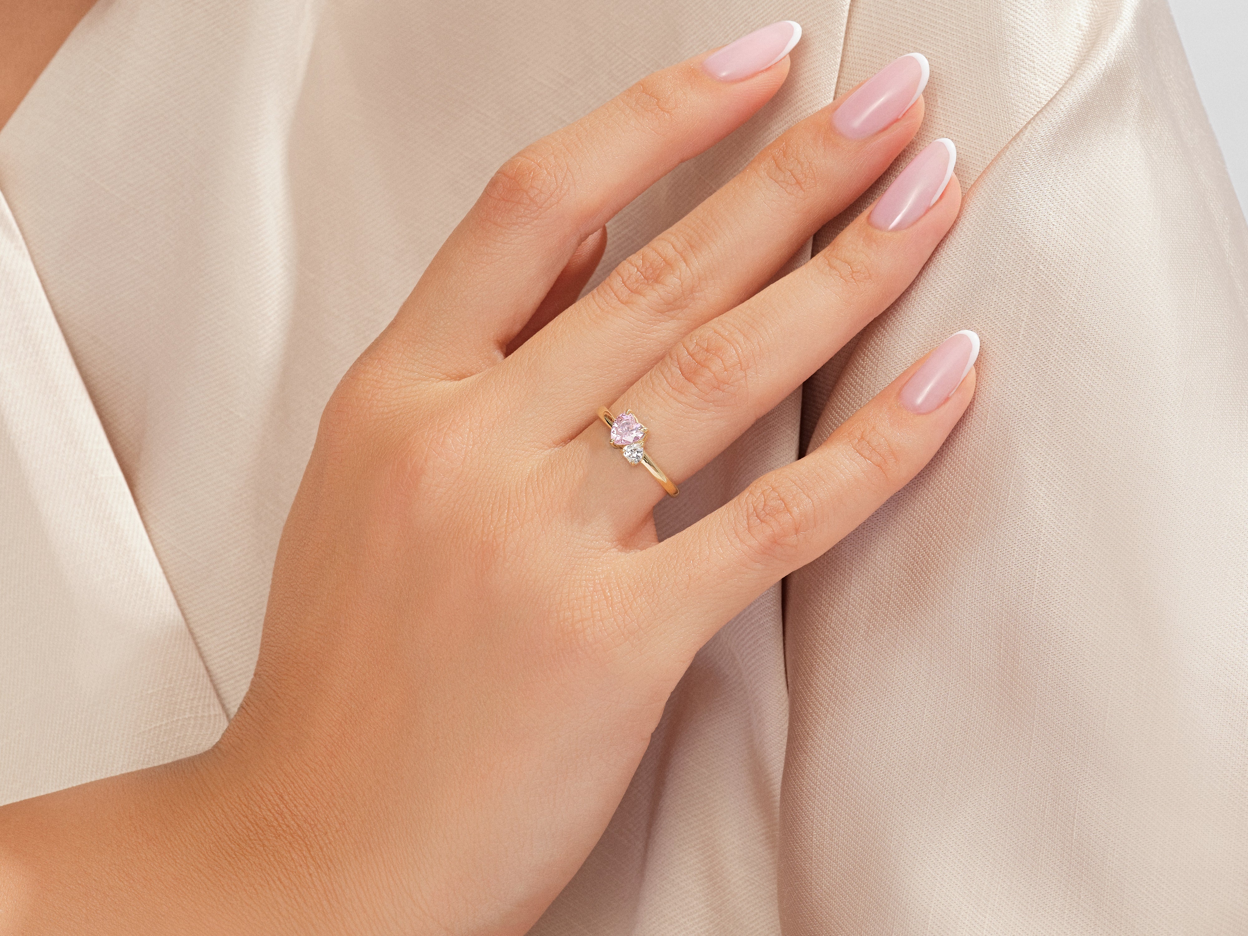 Gold ring with pink and white stones on a woman's hand
