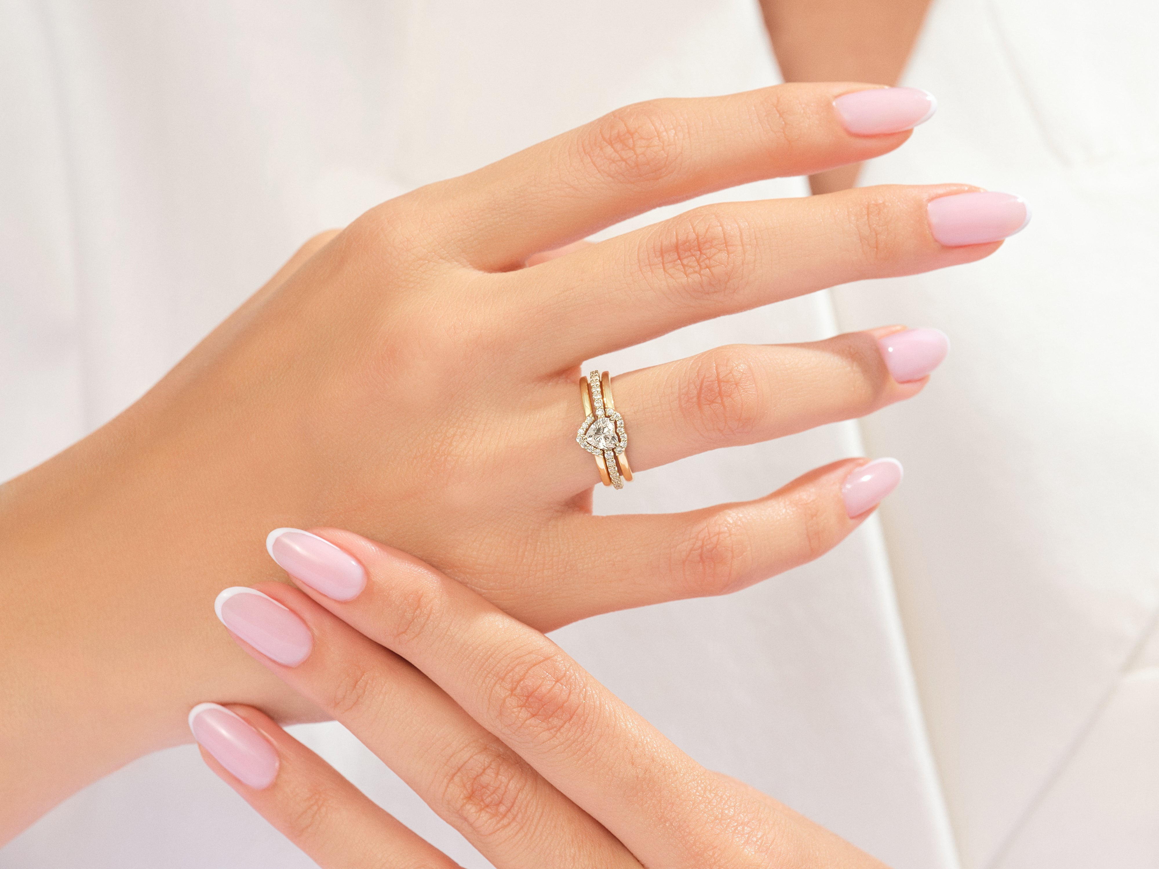 Diamond heart engagement ring set on a woman's hand