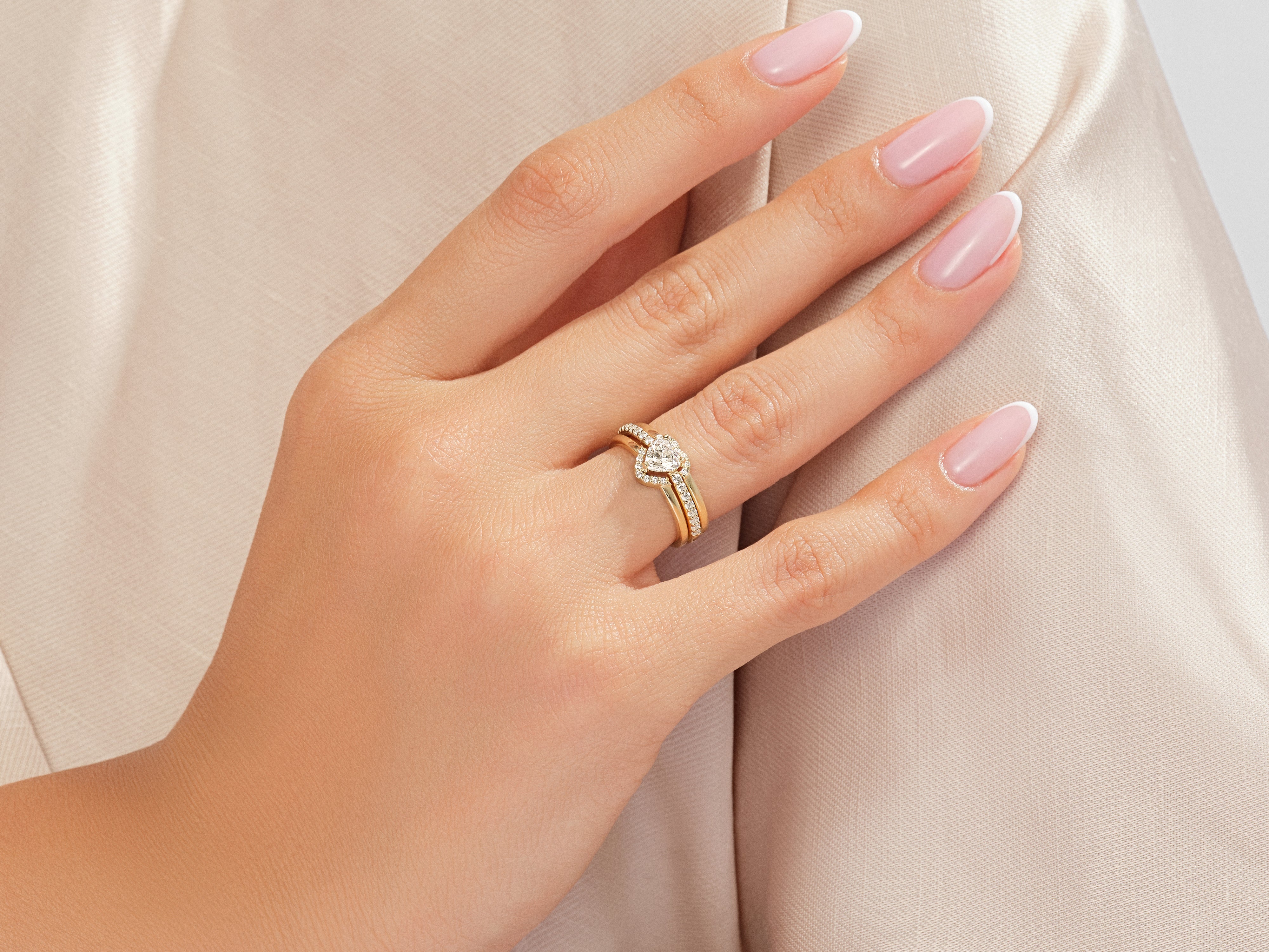 Gold heart diamond engagement ring set on a hand