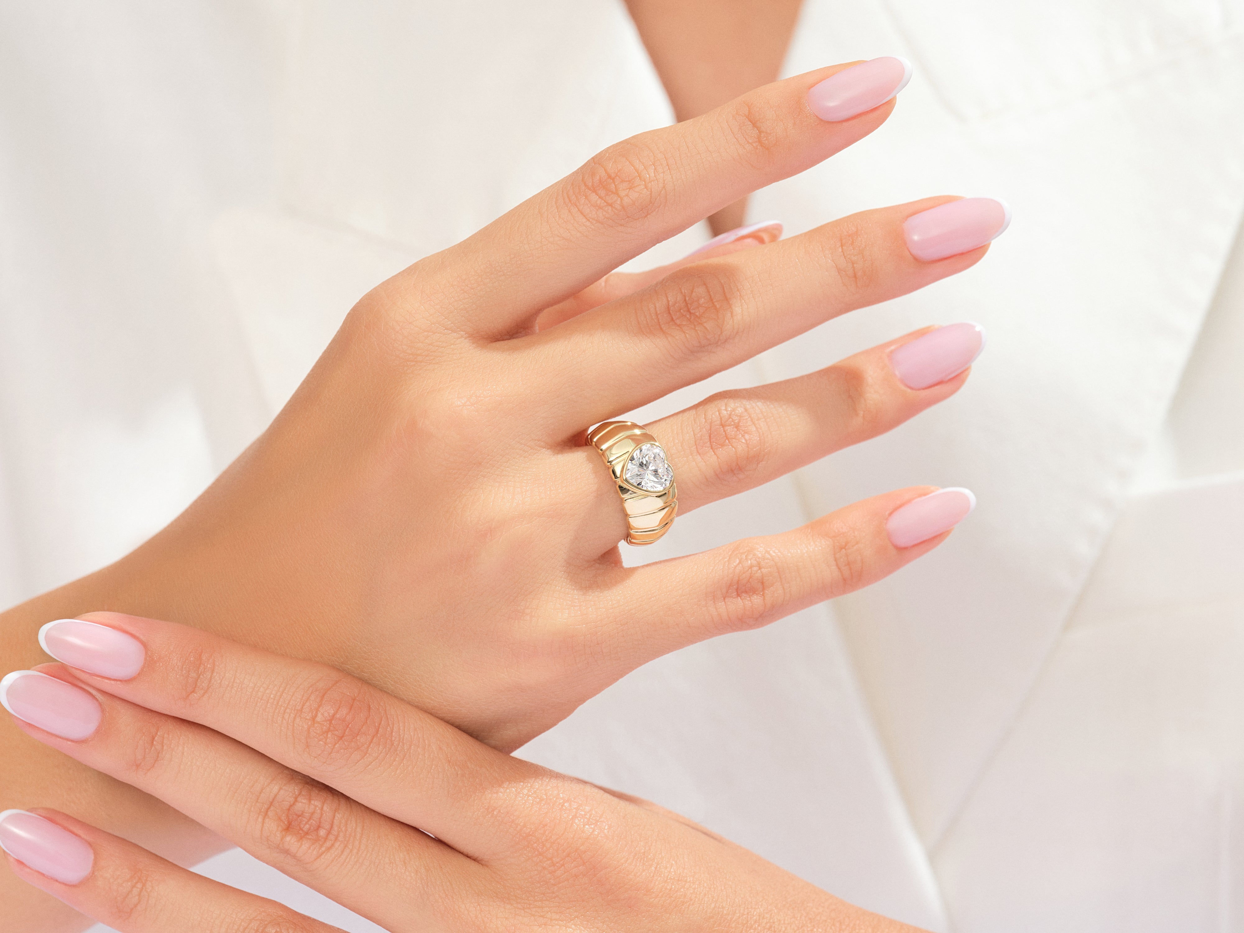 Gold heart diamond ring on elegant hand, luxury jewelry