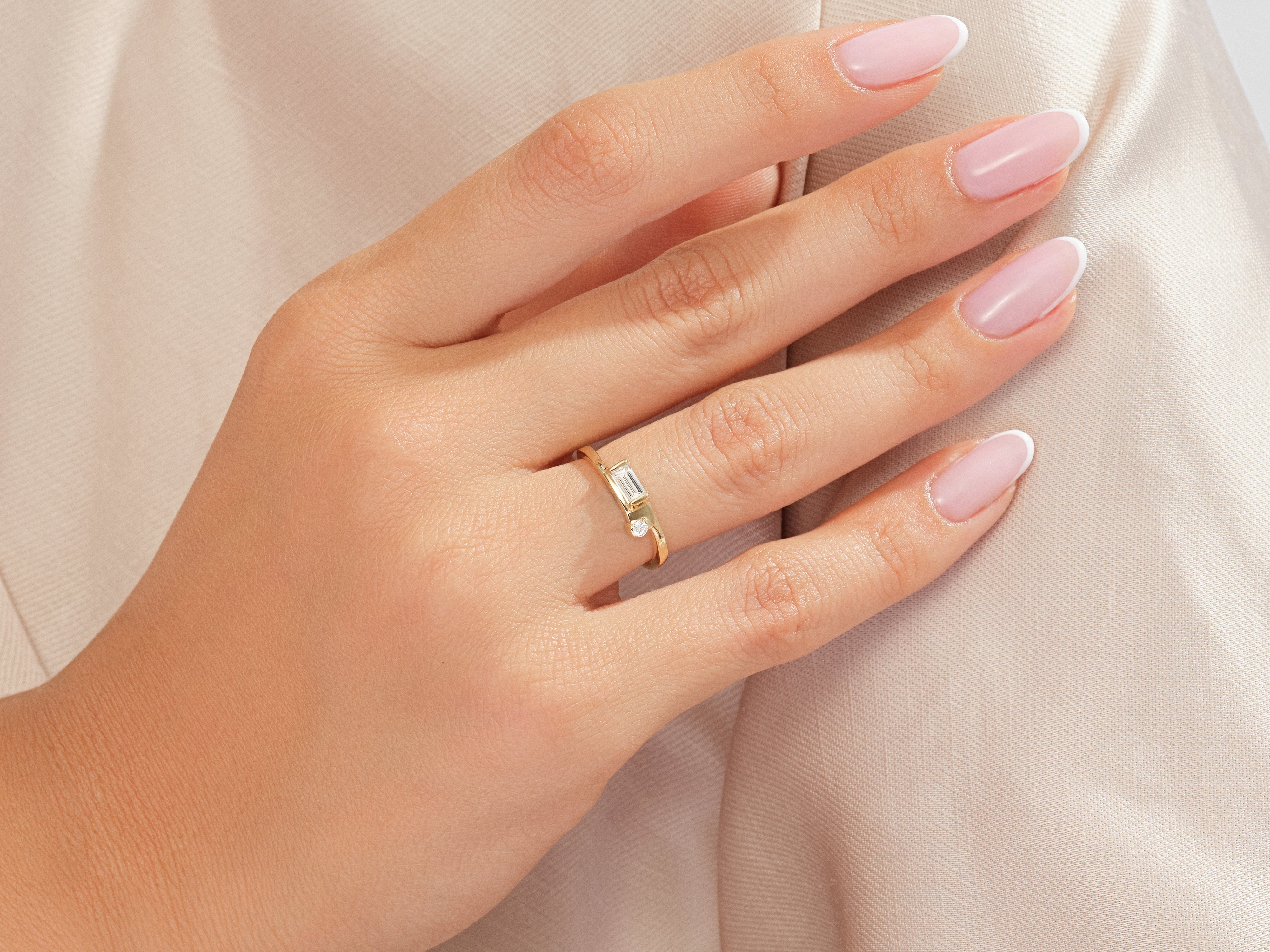 Gold ring with baguette and round diamonds on a hand