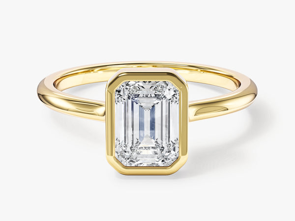 Emerald cut diamond ring in a yellow gold bezel setting
