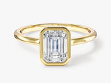 Emerald cut diamond ring in a gold bezel setting
