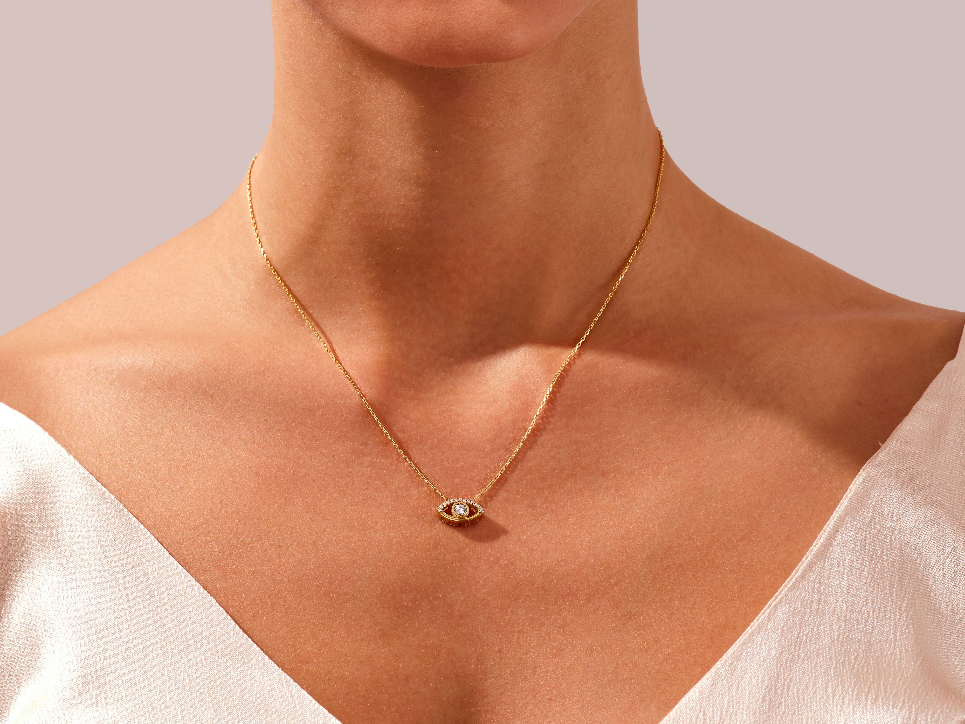 Gold evil eye necklace with diamonds on a woman's neck