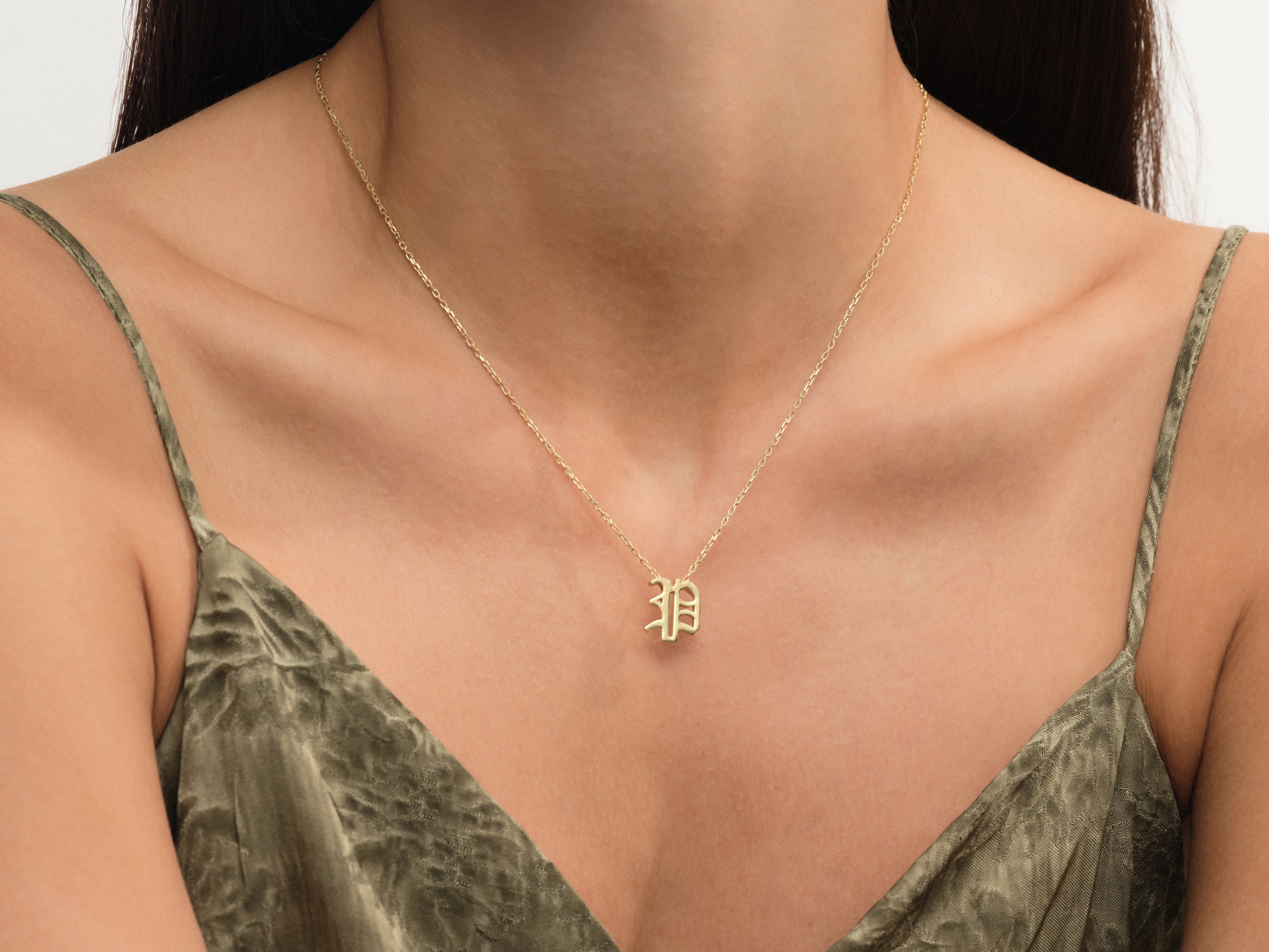 Gold initial necklace on a woman's neck, jewelry