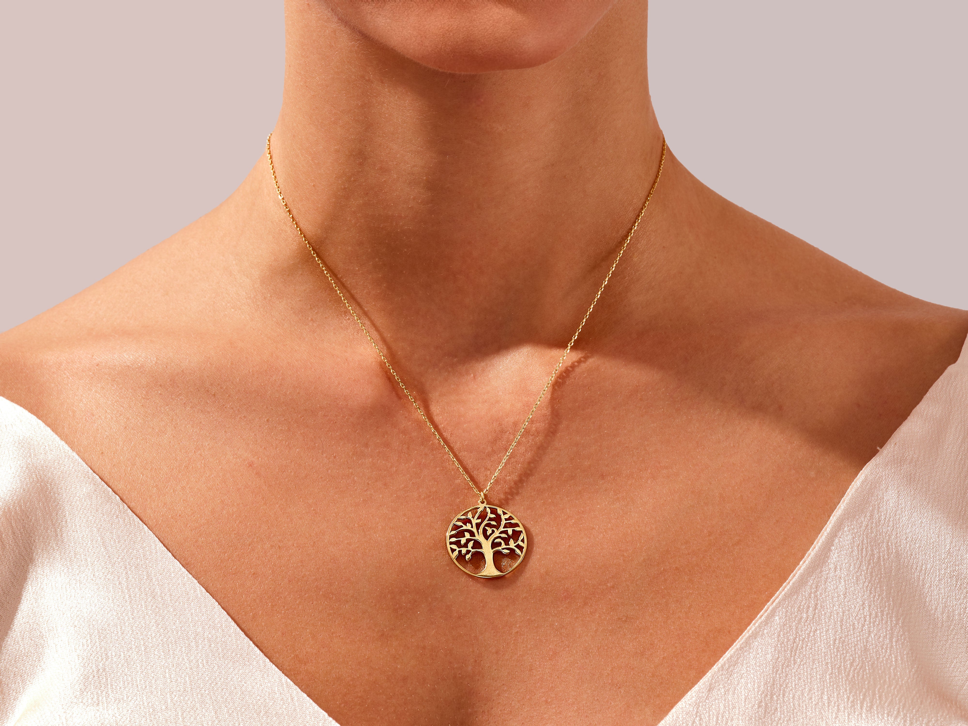 Gold tree of life necklace on woman's neck