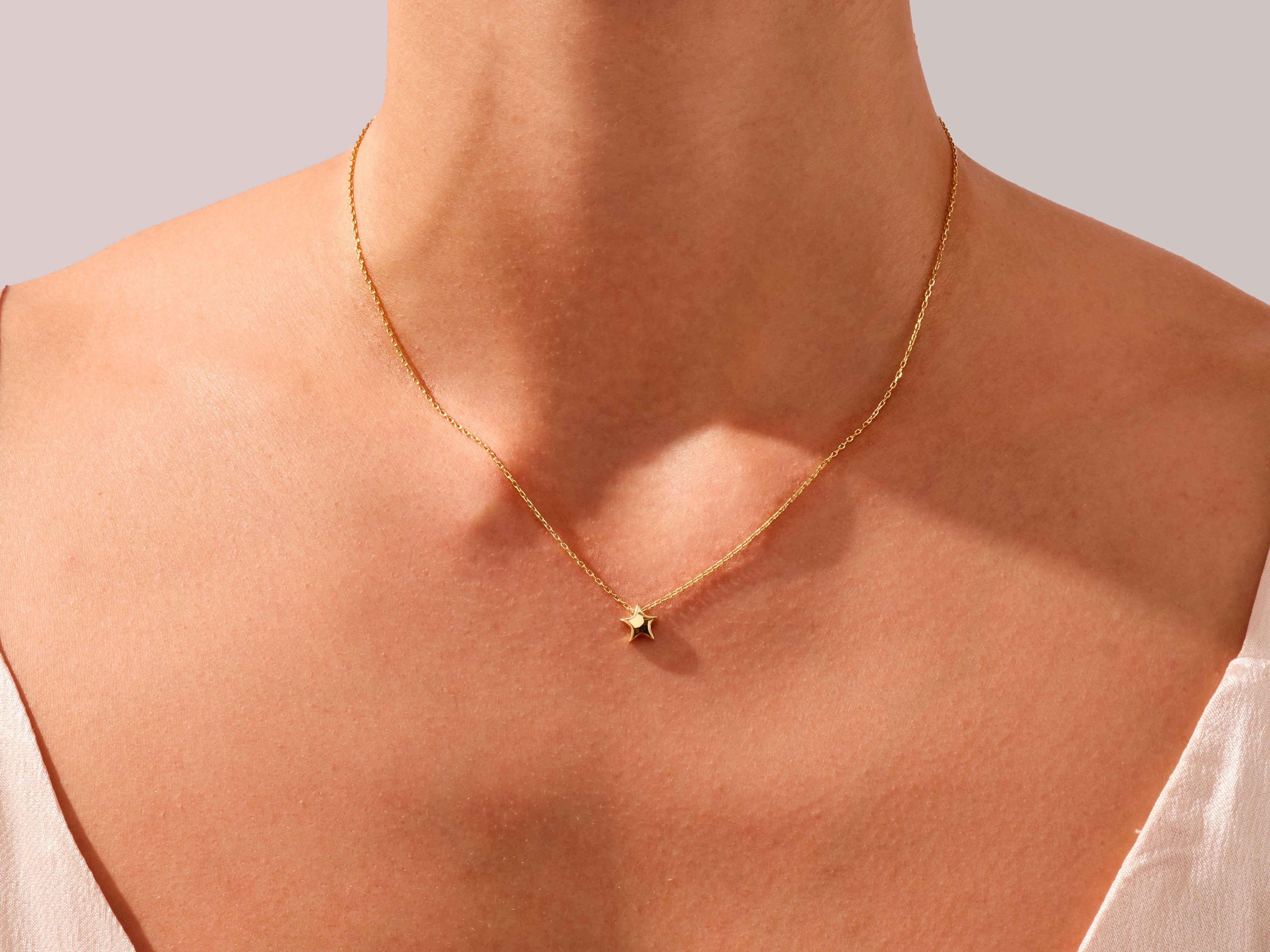 Gold star necklace on a woman's neck, fine jewelry