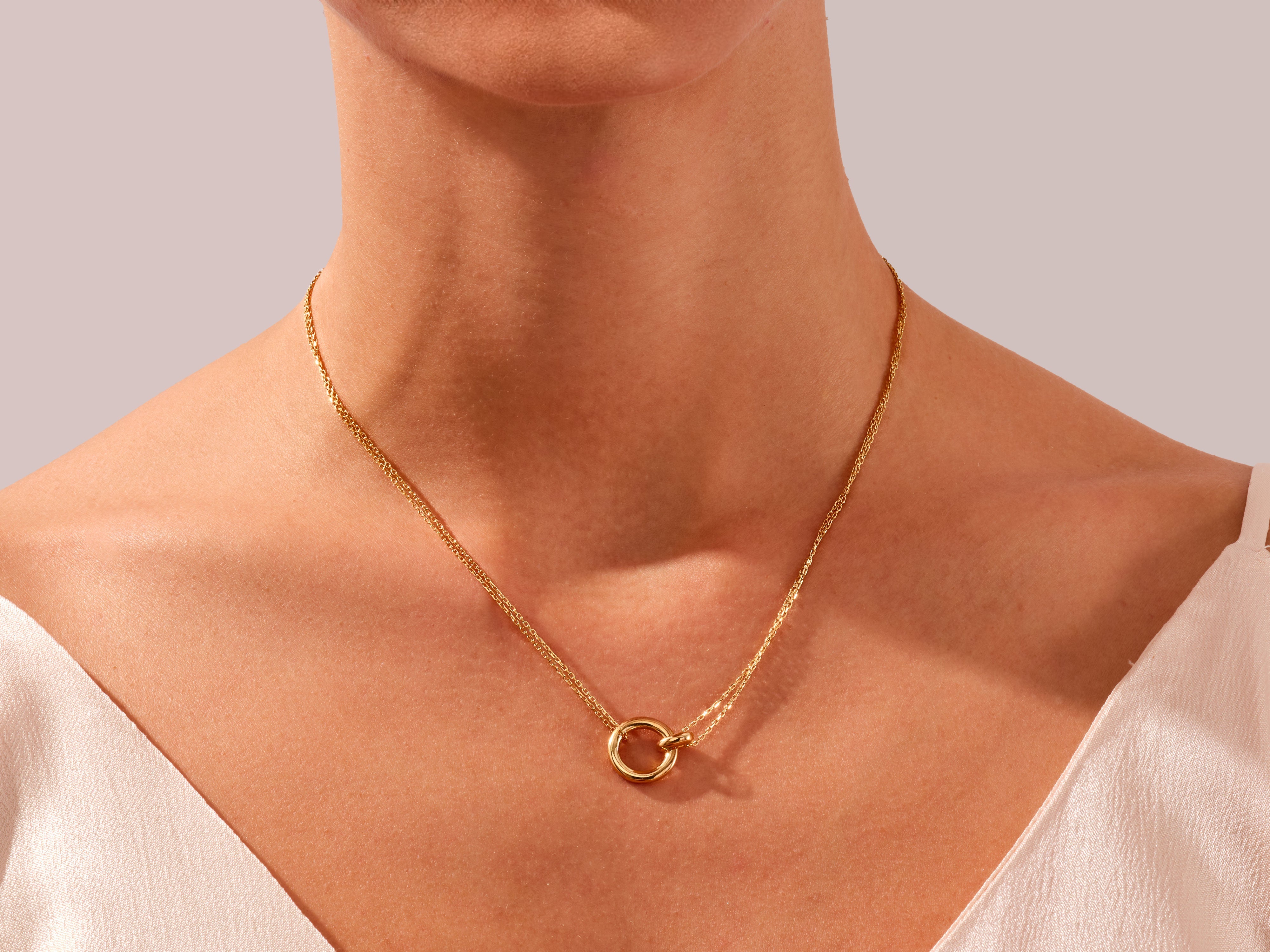 Gold circle pendant necklace on a woman's neck