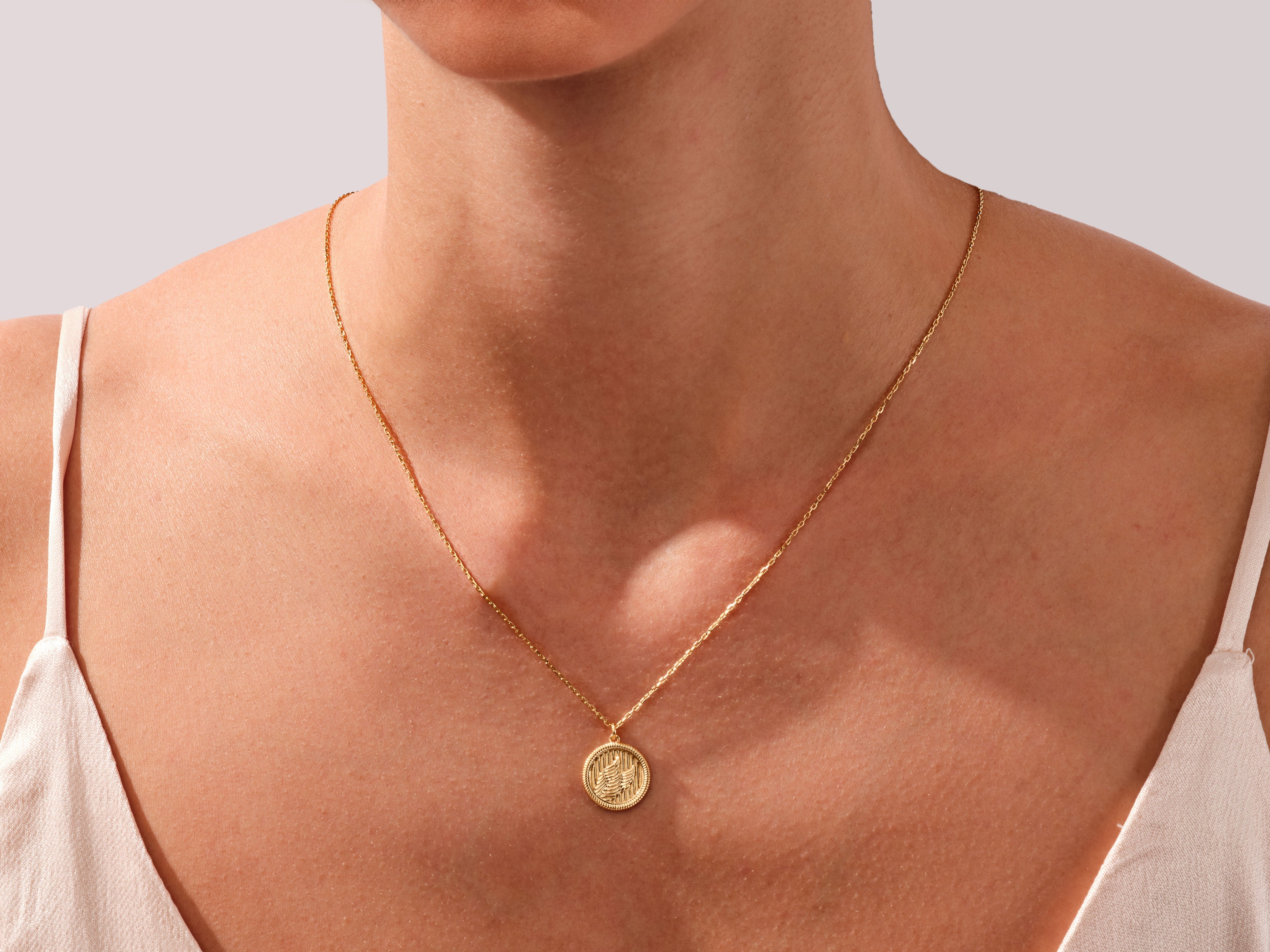 Gold coin pendant necklace on a woman's neck, fine jewelry