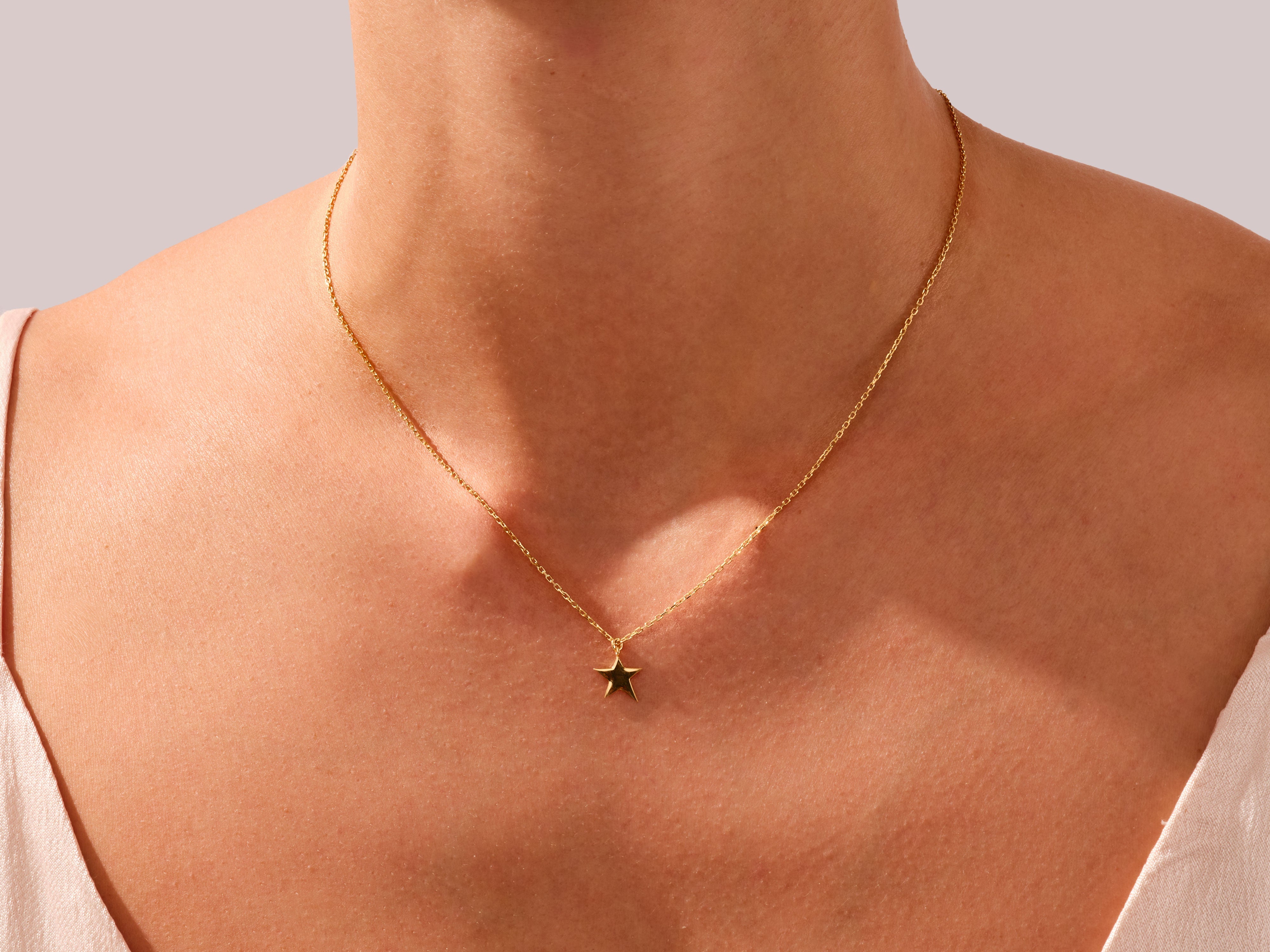 Gold star necklace on a woman's neck, fine jewelry