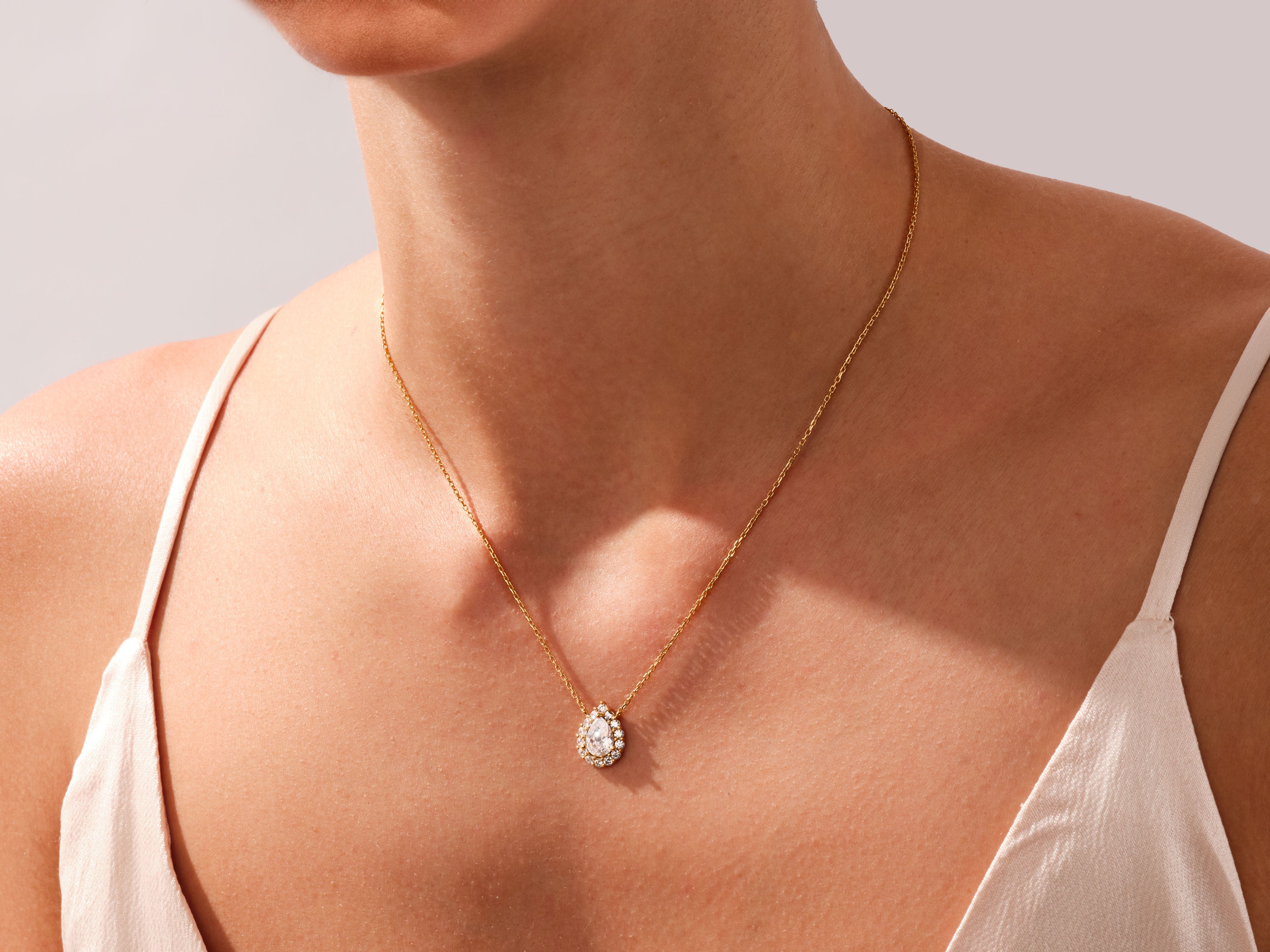 Gold diamond pendant necklace on a woman's neck